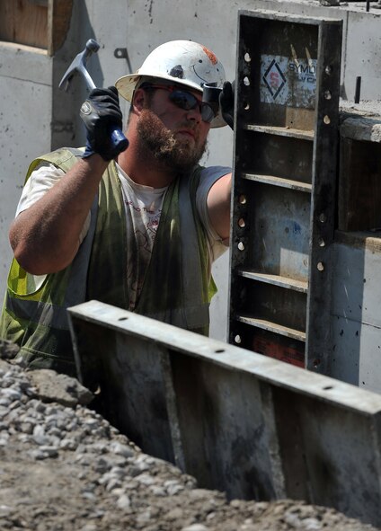 MINOT AIR FORCE BASE, N.D. -- Tony Fugleberg, a construction worker contracted by the 5th Civil Engineering Squadron, separates a guide from a dried foundation wall near Delta Drive here Aug. 6. The base housing expansion is aimed to help improve the comfort of living and decrease the shortage of homes for incoming service members. (U.S. Air Force photo by Senior Airman Michael J. Veloz)