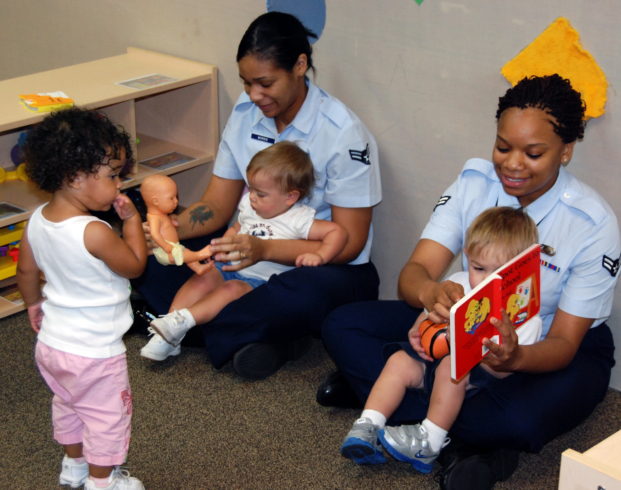 Volunteers from Sheppard’s 54321 Read program take turns reading short stories to the 12 to 24-month children at the Child Development Center at Sheppard Air Force Base, Texas, Aug. 9.  Airman 1st Class Monica Reed (right), 82nd Force Support Squadron student relocations counselor, and Airman 1st Class Krystal Morris(left), 80th Flying Training Wing personnel journeyman, visited several classrooms as they read to various age groups with the CDC.   (U.S. Air Force photo/Tech. Sgt. Vernon Cunningham)