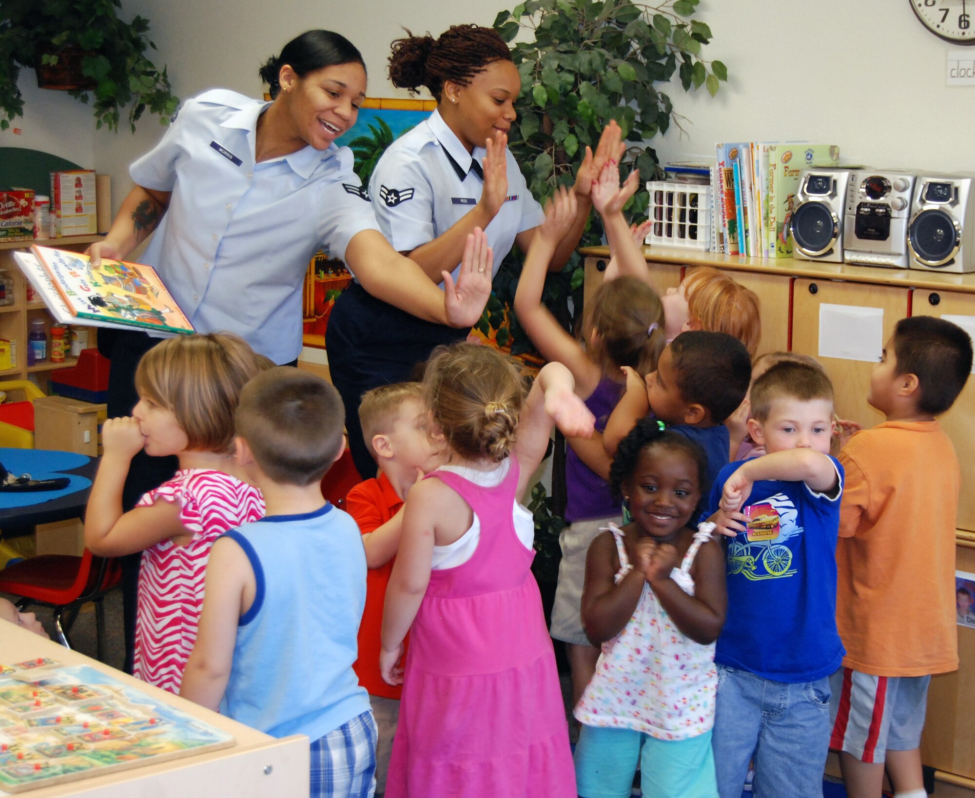 The children of the Child Development Center at Sheppard Air Force Base, Texas, give high fives to the 54321 Read volunteers at the end of their story time Aug. 9.  Airman 1st Class Monica Reed (right), 82nd Force Support Squadron student relocations counselor, and Airman 1st Class Krystal Morris(left), 80th Flying Training Wing personnel journeyman, took turns reading various short stories during their biweekly tour of the CDC.  (U.S. Air Force photo/Tech. Sgt. Vernon Cunningham)