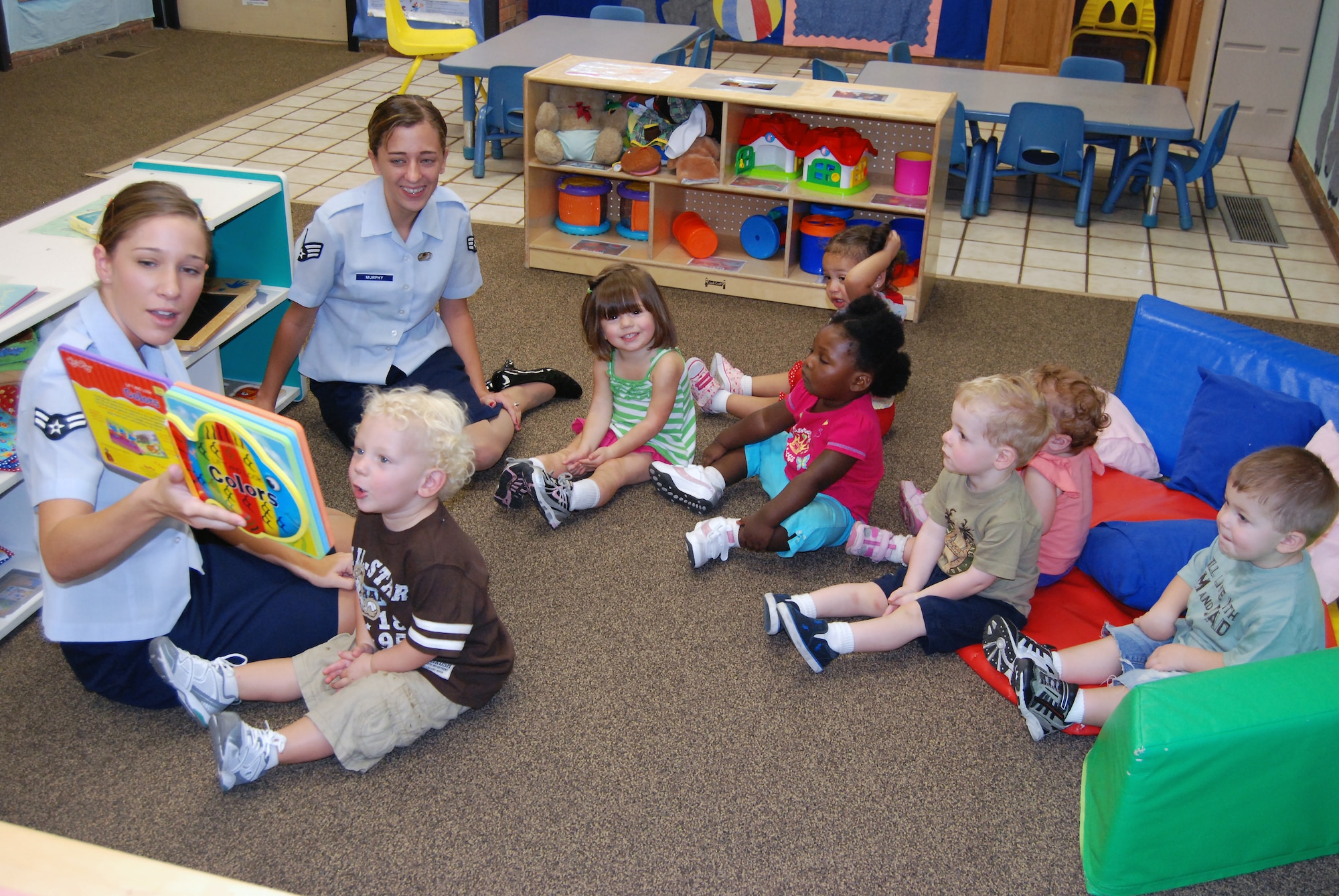 Volunteers from Sheppard’s 54321 Read program visit the Child Development Center at Sheppard Air Force Base, Texas, Aug. 9 to read to the 1-year-olds during story time.  Airman 1st Class Erica Heal (front), 82nd Force Support Squadron personnel relocation apprentice, and Senior Airman Katrina Murphy (back), 82nd FSS force management journeyman, read various short stories to children of different ages as they moved from room to room in the CDC.  (U.S. Air Force photo/Tech. Sgt. Vernon Cunningham)