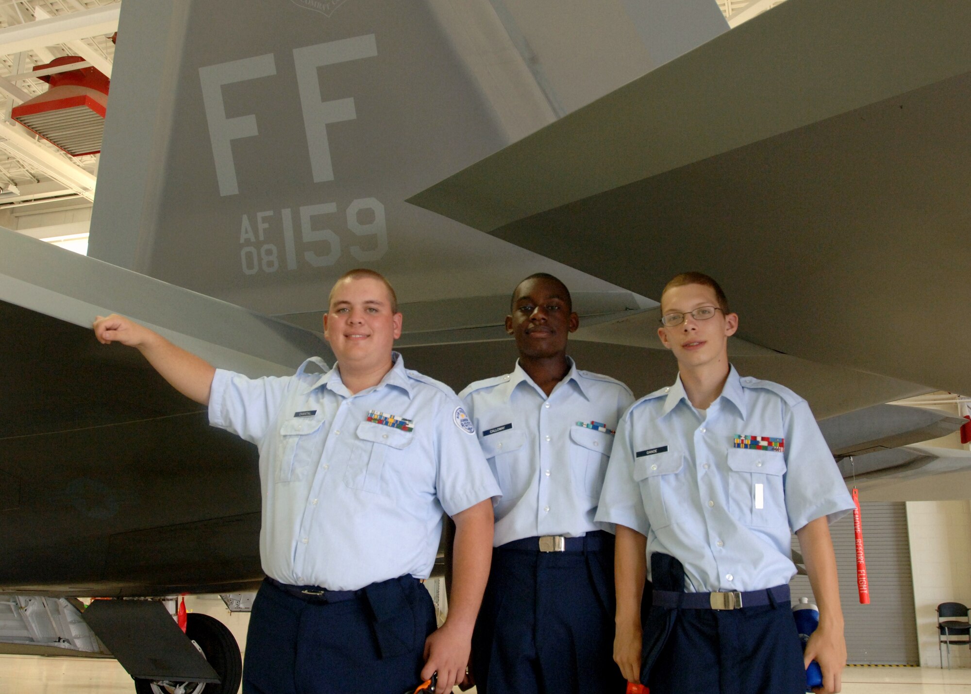 LANGLEY AIR FORCE BASE, Va. -- (From left) Air Force Junior Reserve Officer Training Corps Cadets Sean Chantal, Emmett Calloway and Michael Ganoe pose with a 27th Fighter Squadron F-22 Raptor during “Shadow Day” Aug. 10. The event allowed more than 60 Hampton Roads-area cadets the opportunity to see the Air Force mission in action. (U.S. Air Force photo/Airman 1st Class Jason J. Brown)