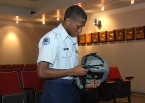 LANGLEY AIR FORCE BASE, Va. -- Cadet Trey Cross, a Lakeland High School Air Force Junior Reserve Officer Training Corps cadet, inspects a fighter pilot helmet following an F-15 Eagle mission capabilities briefing during “Shadow Day” Aug. 10. The event allowed more than 60 Hampton Roads-area cadets the opportunity to see the Air Force mission in action. (U.S. Air Force photo/Airman 1st Class Jason J. Brown)