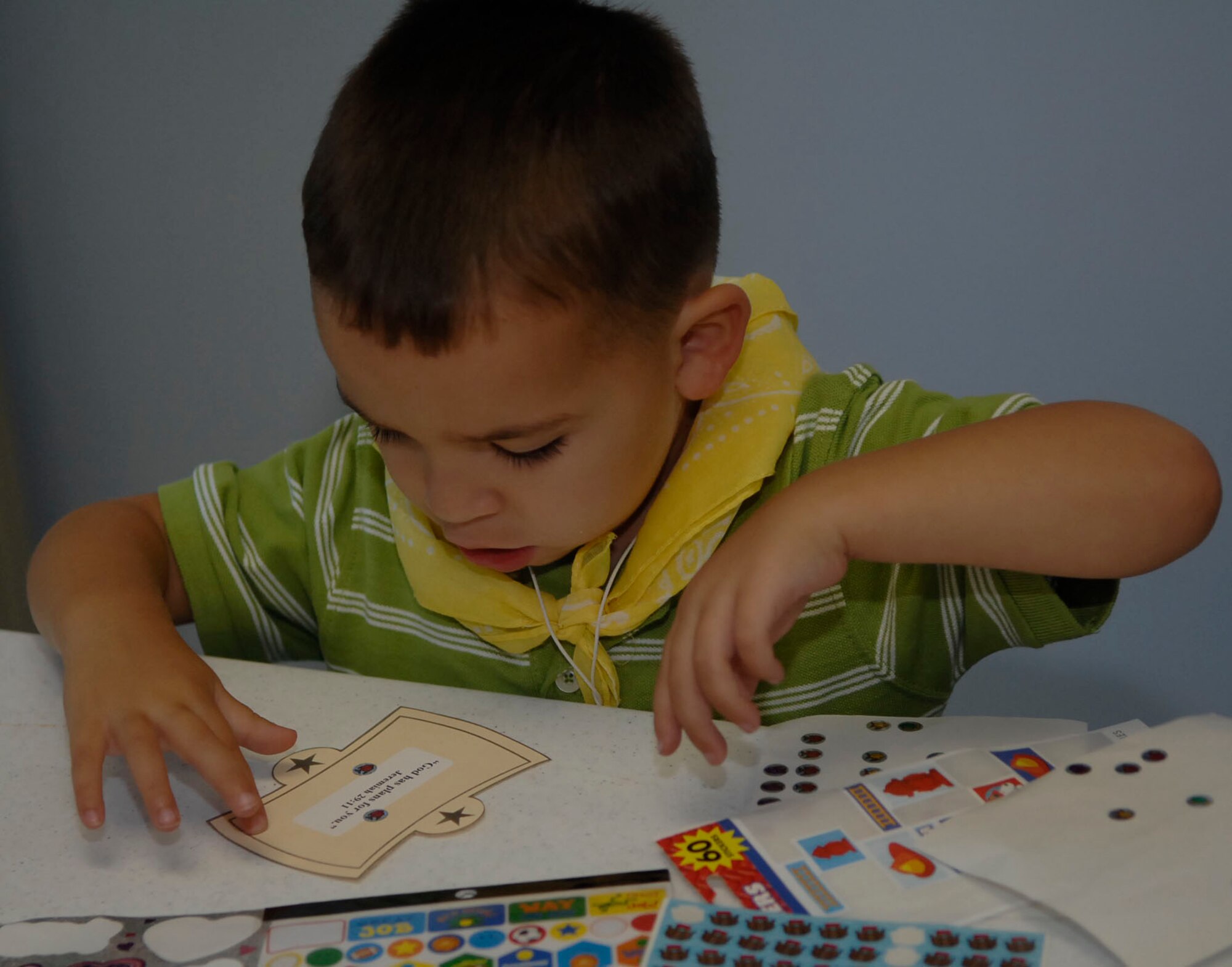 SCOTT AIR FORCE BASE, Ill. -- Jackson Sandifer, 3, puts stickers on his Bible quotes at Vacation Bible School.  The camp was Aug. 2–6 with different religious themes each day.
