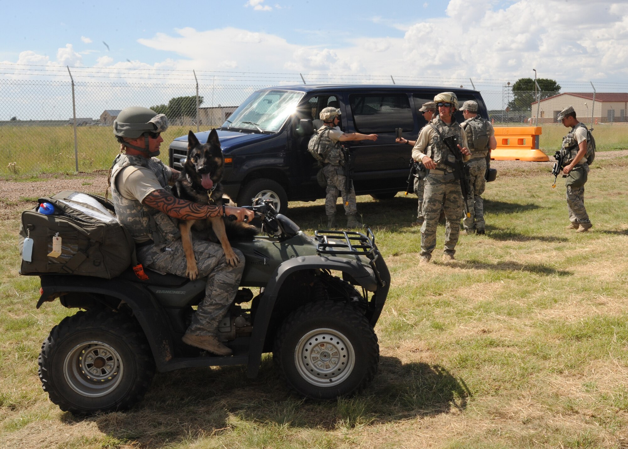 Staff Sgt. Adam Wylie, 27th Special Operations Security Forces Squadron, and his military working dog, Jackson, go for a ride on an ATV Aug. 10,2010 during an exercise. For quick responses, these trained police dogs have to be ready to go at a moments notice. (U.S. Air Force photo by Airman 1st Class Maynelinne De La Cruz)
