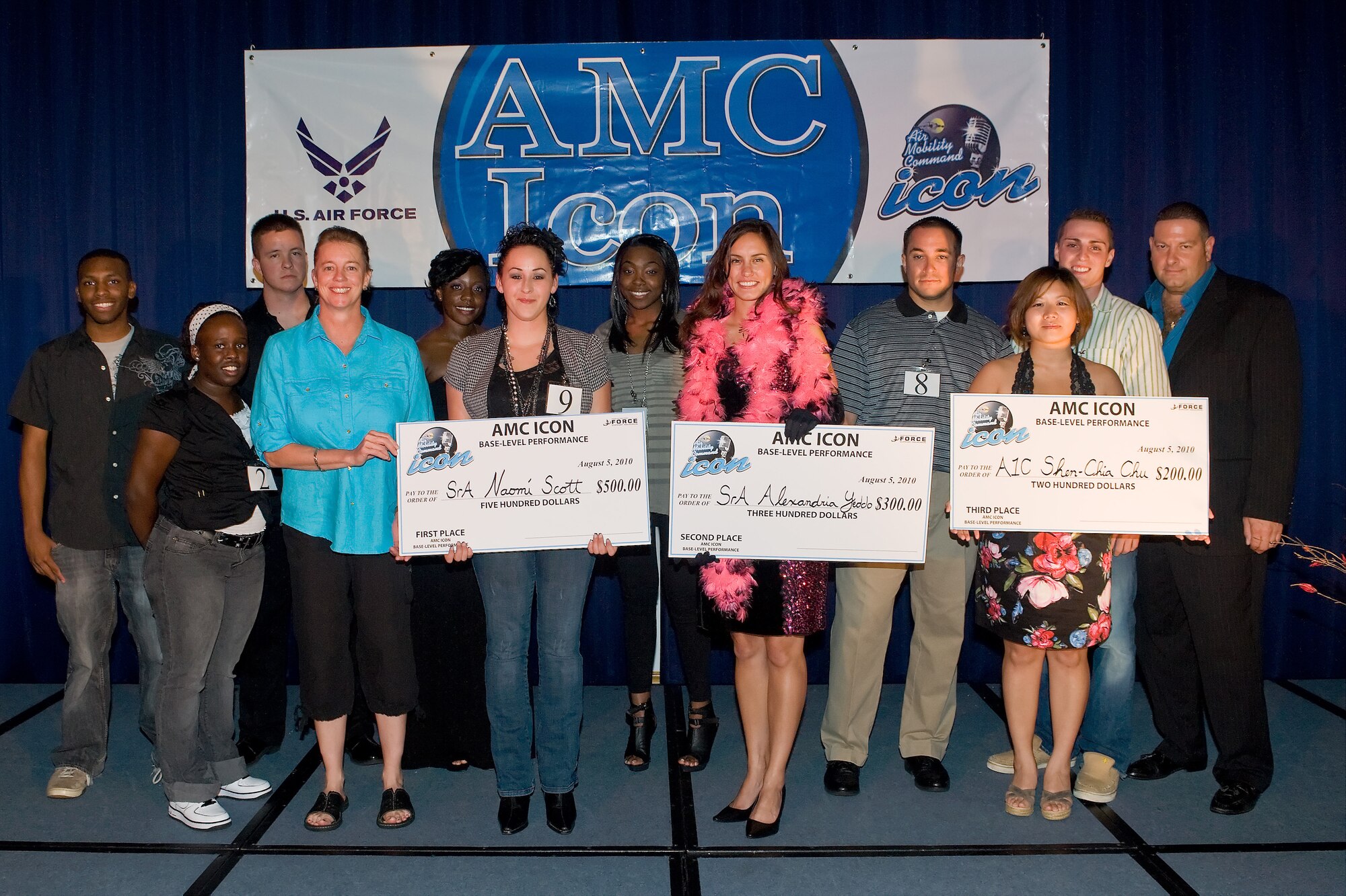 (Front Left to Right) Col. Joan H. Garbutt, 436th Mission Support Group commander, presented big checks at The Landings Club to the top three Air Mobility Command Icon winners: Senior Airman Naomi Scott, 436th Maintenance Squadron, Senior Airman Alexandria Yeddo, 436th Communications Squadron and Airman 1st Class Shen-Chia Chu, 436th Public Affairs, Aug. 5, 2010. There were 11 AMC Icon contestants for this year?s event. (U.S. Air Force photo by Roland Balik/Released)