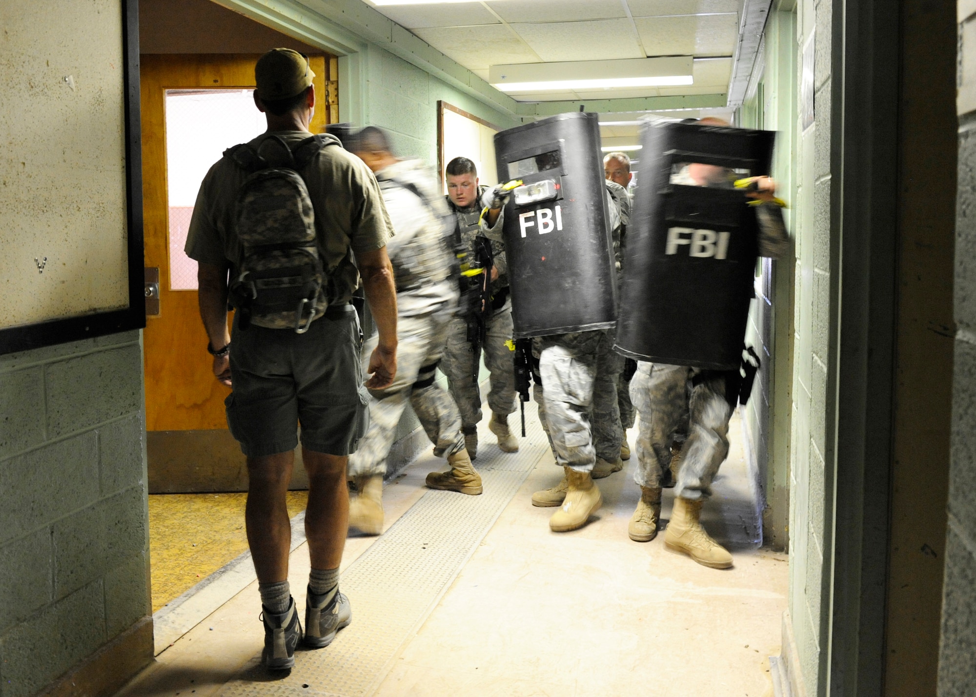 HOLLOMAN AIR FORCE BASE, N.M. -- Special Agent Raymond Gonzales, training coordinator with the Federal Bureau of Investigation, Albuquerque division, oversees members of the 49th Security Forces Squadron as they practice close-quarter battle and ballistic shield work during training August 6, 2010. The FBI assisted Airmen of Holloman to build on their partnership with the military and local law enforcement and to practice techniques that could be used in a real-world crisis situation. (U.S. Air Force photo by Airman 1st Class Eileen Payne / Released)