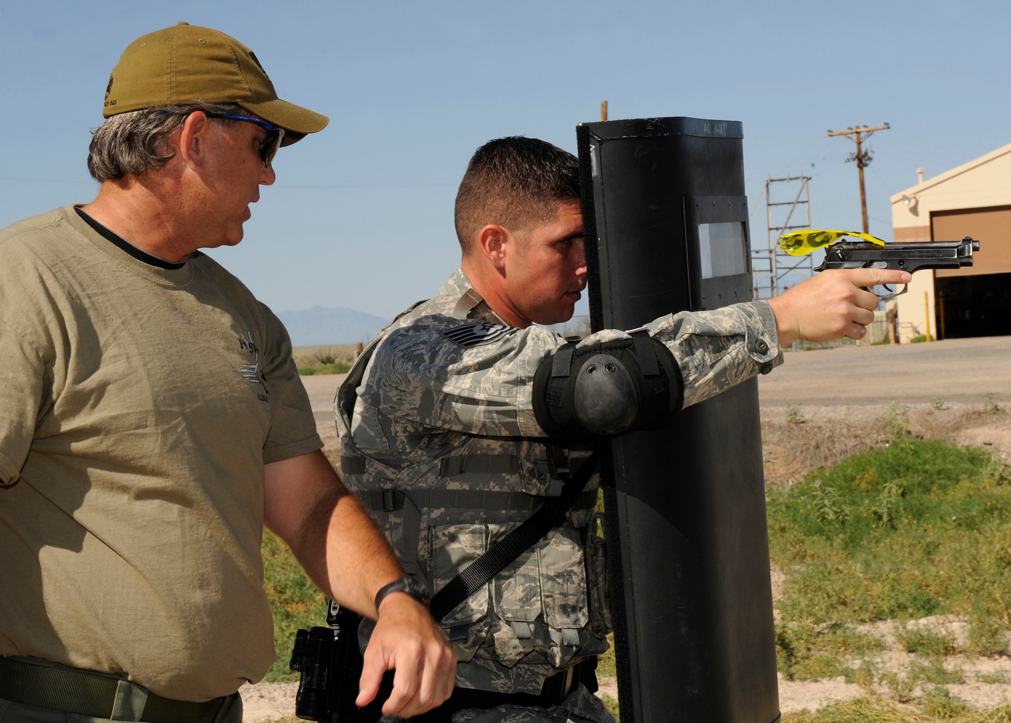 HOLLOMAN AIR FORCE BASE, N.M. -- Special Agent Rich Price, training coordinator with the Federal Bureau of Investigation, Albuquerque division, assists Tech. Sergeant Thomas Henzl, 49th Security Forces Squadron Military Working Dog Flight, with basic ballistic shield work during training August 6, 2010. The FBI assisted Airmen of Holloman to build on their partnership with the military and local law enforcement. (U.S. Air Force photo by Airman 1st Class Eileen Payne / Released)