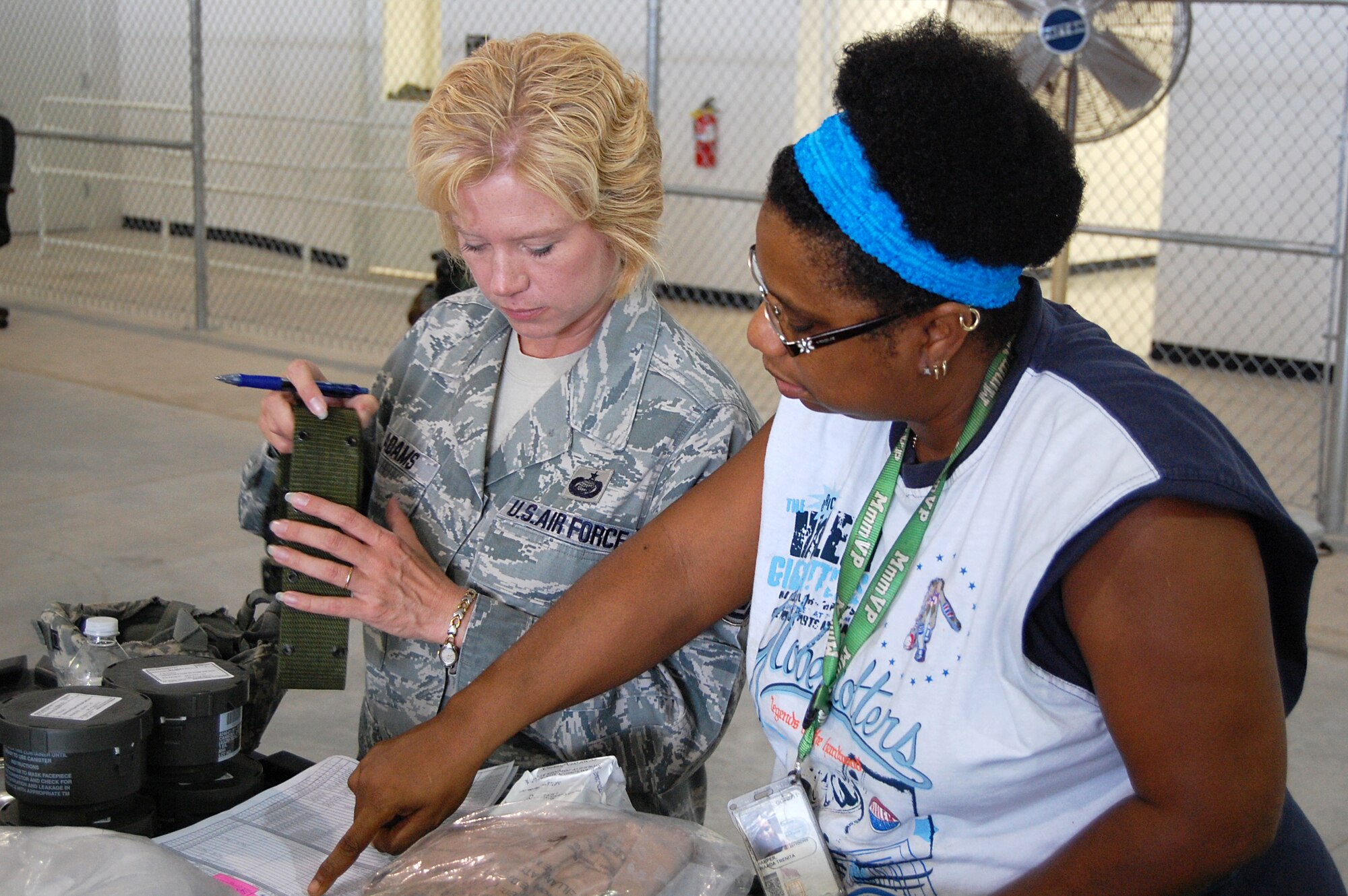 Wanda Harper, 902nd Logistics Readiness Squadron, assists Tech. Sgt. Dawn Adams, Air Force Personnel Center, in inventorying her equipment at the 902nd Logistics Readiness Squadron Deployment Processing Center on Randolph Air Force Base Aug. 10. During exercise Joint Base San Antonio 10-08, more than 200 Airmen from different agencies on Randolph AFB participated in the two-day deployment exercise. (U.S. Air Force photo/Master Sgt. Paul Kilgallon)