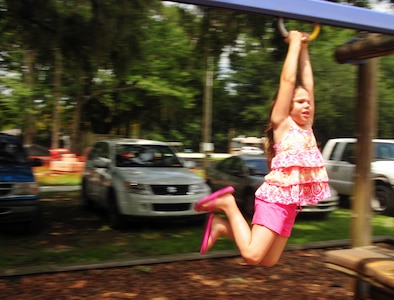 Stephanie Wright holds tightly as she glides to safety at the base picnic grounds during the base library's summer reading finale Aug. 7, 2010, at Joint Base Charleston, S.C. The picnic grounds proved an action-packed setting for children who participated in the program. Stephanie performed aerial acrobatics while accompanied by her five siblings as the children's "Voyage to Book Island" came to a close. Stephanie is the daughter of Tech. Sgt. Stephen Wright who is with the 81st Aerial Port Squadron and is currently deployed to the Middle East. (U.S. Air Force photo/Staff Sgt. Daniel Bowles)