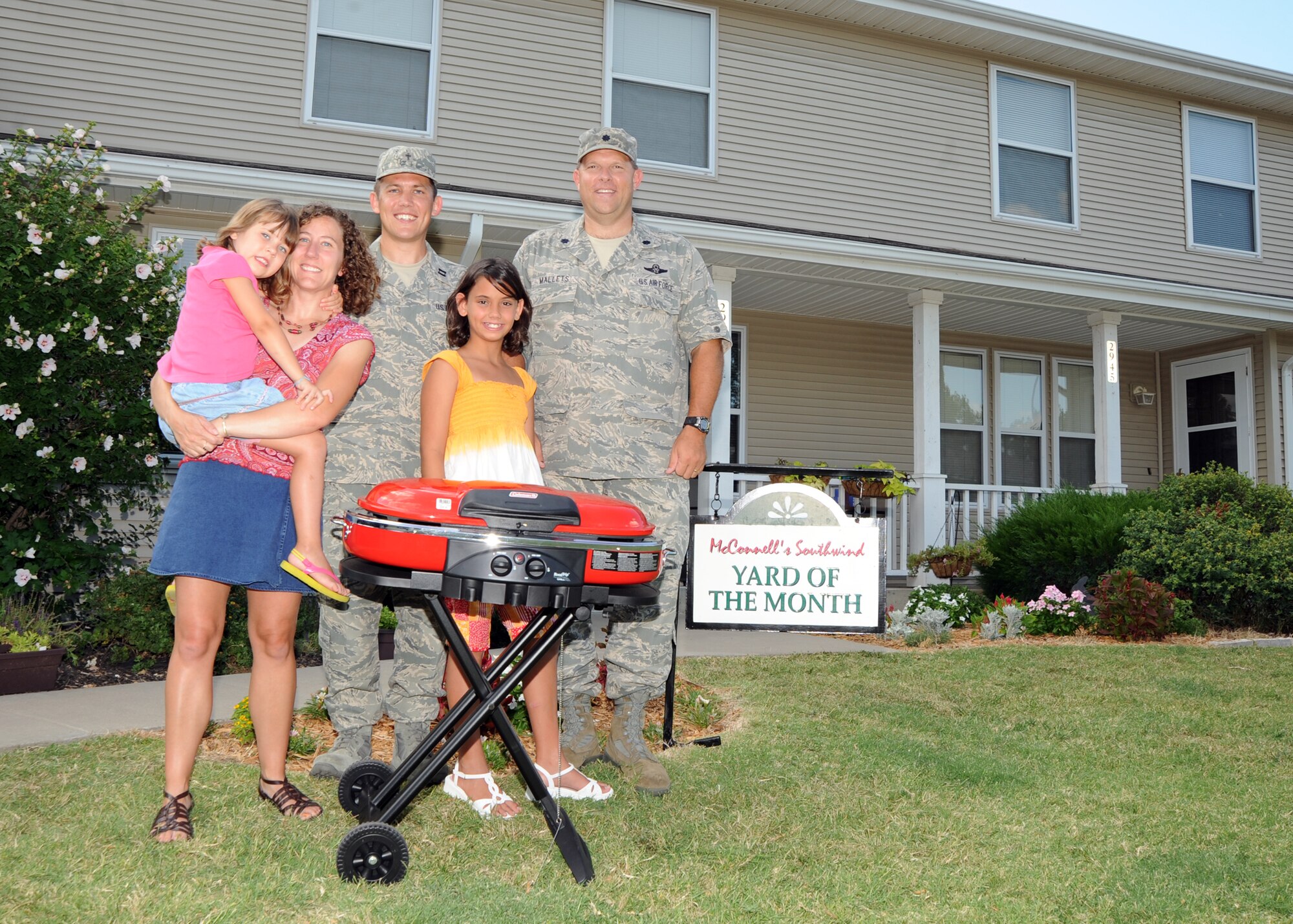 Lt. Col. Robert Mallets, 22nd Mission Support Group deputy commander, presents Capt. Quentin Genke, 22nd Air Refueling Wing chaplain, his wife Sonja, children Annika and Atanaska, with a portable grill Aug. 5, 2010, McConnell Air Force Base, Kan., for earning the McConnell’s Yard of the Month for July,.  The Genke family was awarded Army and Air Force Exchange Service gift cards and other prizes.  McConnell will announce one more monthly winner for the month of August.  The Yard of the Month recognizes the best landscaping and lawn care in base housing.  (U.S. Air Force photo/Airman 1st Class Andrea Salazar)