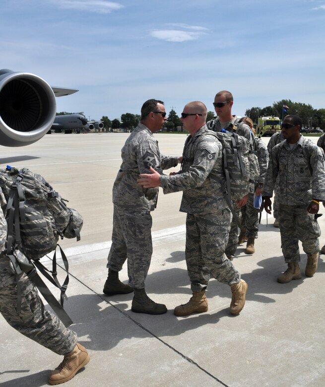 Command Chief Master Sgt. Joseph Parlato, the 128th Air Refueling Wing security forces manager, gives deploying security forces team members a farewell embrace as the Airmen board an aircraft.  The security forces Airmen deployed to Southwest Asia to perform base security operations in support of Operation Enduring Freedom.  (U.S. Air Force photo by Senior Airman Ryan Kuntze / released)