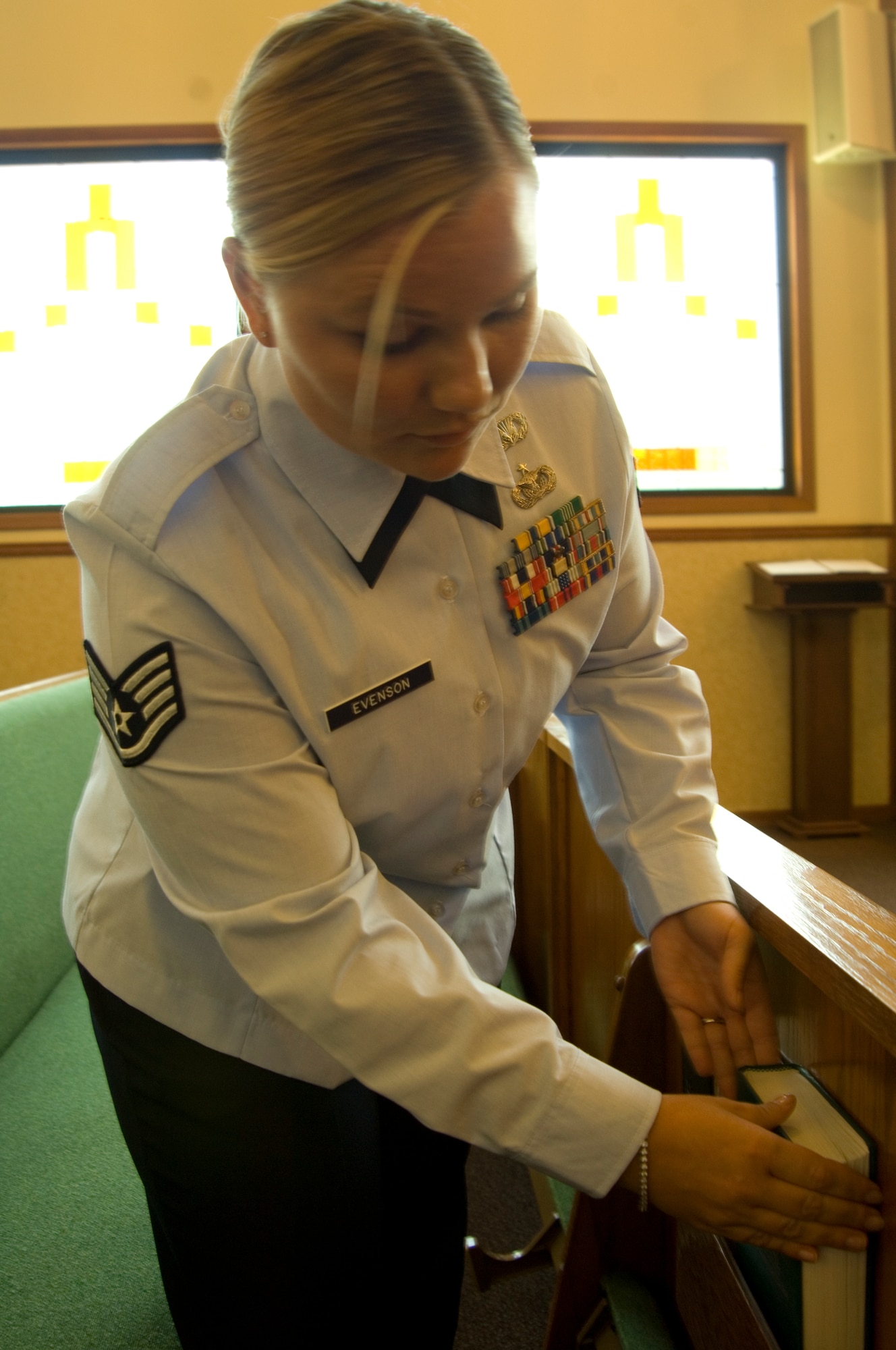 Staff Sgt. Nichole S. Evenson, 22nd Air Refueling Wing religious program support NCOIC, organizes the base chapel before a religious ceremony Aug. 9, 2010, McConnell Air Force Base, Kan.  In addition to organizing the interior of the base chapel, the Clearfield, Pa., native facilitates religious program support for worship, liturgies and rites while also partnering with chaplains in contingency operations, traumatic stress responses, spiritual triage and ministry of presence visitations. (U.S. Air Force photo/Senior Airman Abigail Klein)