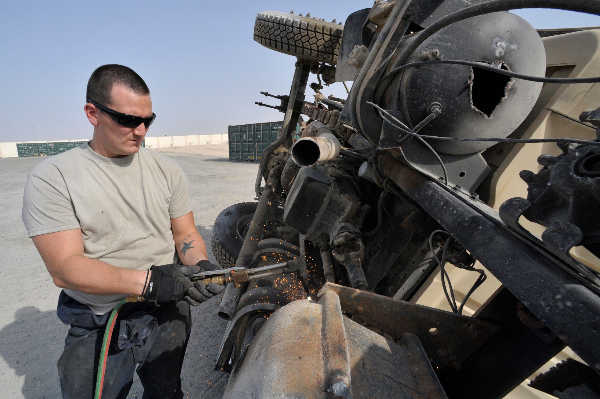 Staff Sgt. Charles Smith, 380th Expeditionary Logistics Readiness Squadron vehicle maintenance technician, uses a blow torch to destroy vehicles Aug. 9 at an undisclosed location in Southwest Asia.  Maintenance technicians make vehicles inoperative by cutting a three inch hole in the engine block and transmission and by cutting the frame in half. This is done so that the vehicle can’t be used for its original purpose. The 380th ELRS has saved over $684,000 by destroying the vehicles here rather than sending them to the Defense Reutilization and Marketing Office (DRMO). (U.S. Air Force photo/ Staff Sgt. Thomas Kessler) 