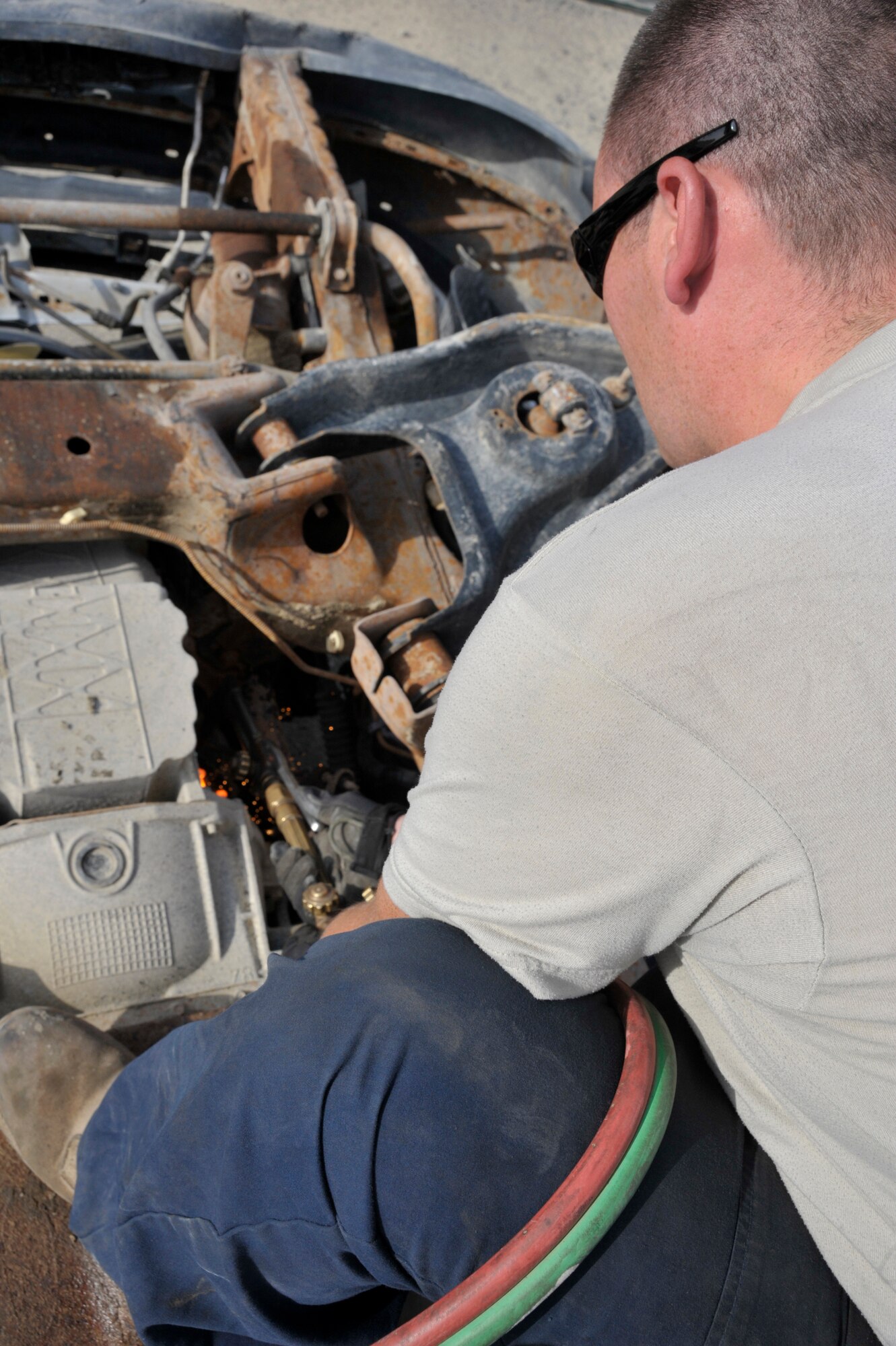 Staff Sgt. Charles Smith, 380th Expeditionary Logistics Readiness Squadron vehicle maintenance technician, uses a blow torch to destroy vehicles Aug. 9 at an undisclosed location in Southwest Asia.  Maintenance technicians make vehicles inoperative by cutting a three inch hole in the engine block and transmission and by cutting the frame in half. This is done so that the vehicle can’t be used for its original purpose. The 380th ELRS has saved over $684,000 by destroying the vehicles here rather than sending them to the Defense Reutilization and Marketing Office (DRMO).  (U.S. Air Force photo/ Staff Sgt. Thomas Kessler) 