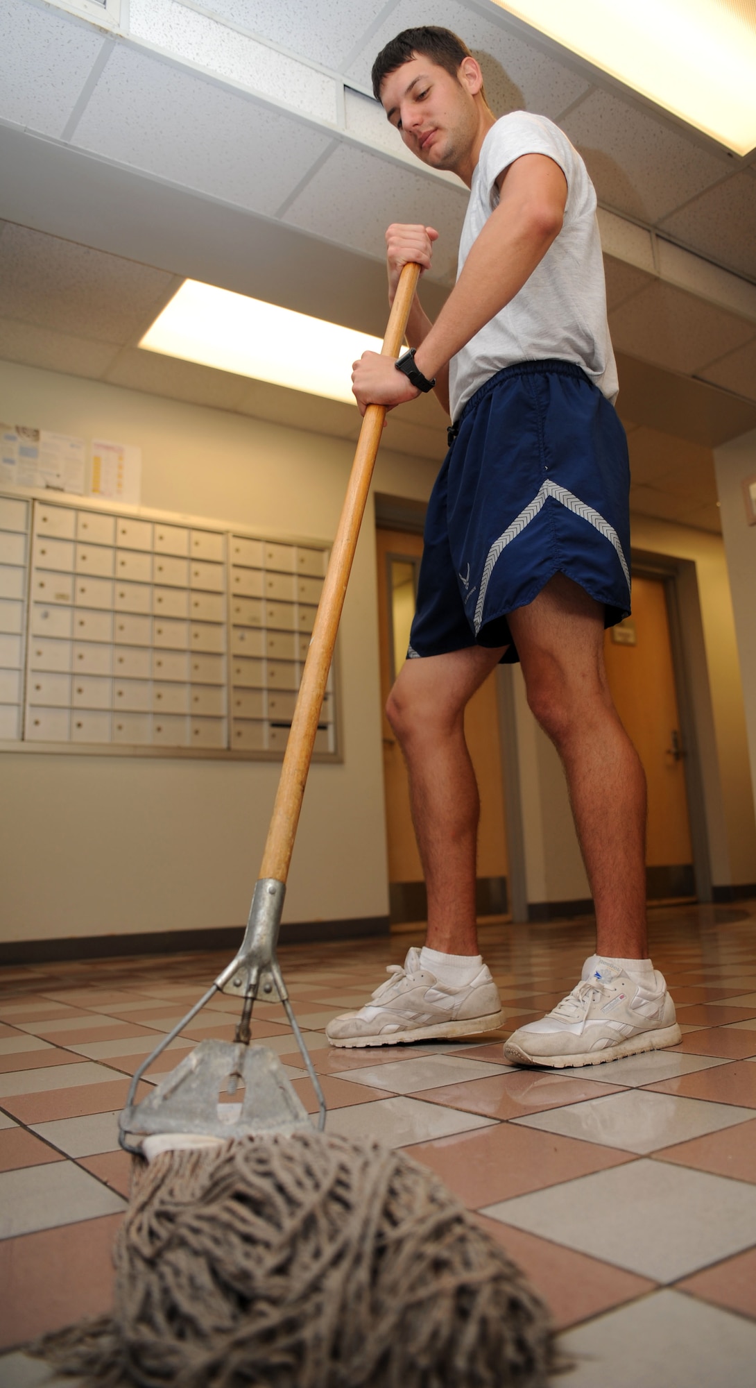 Airman 1st Class Clay Reiney mops the entry to Dorm building 464 during his one week bay orderly detail at Joint Base Charleston, S.C., Aug. 10, 2010. Bay orderly detail consists of an eight-and-a-half hour day that begins at 8 a.m. and ends at 4:30 p.m. Airmen's responsibilities include emptying the garbage cans throughout the building, picking up cigarette butts, serving as an escort to guide workers through the building and sanitizing the dorm in order to provide better living conditions for Airmen who reside in the dorms. Airman Reiney is a supply apprentice with the 628th Logistics Readiness Squadron. (U.S. Air Force Photo/Airman 1st Class Lauren Main)