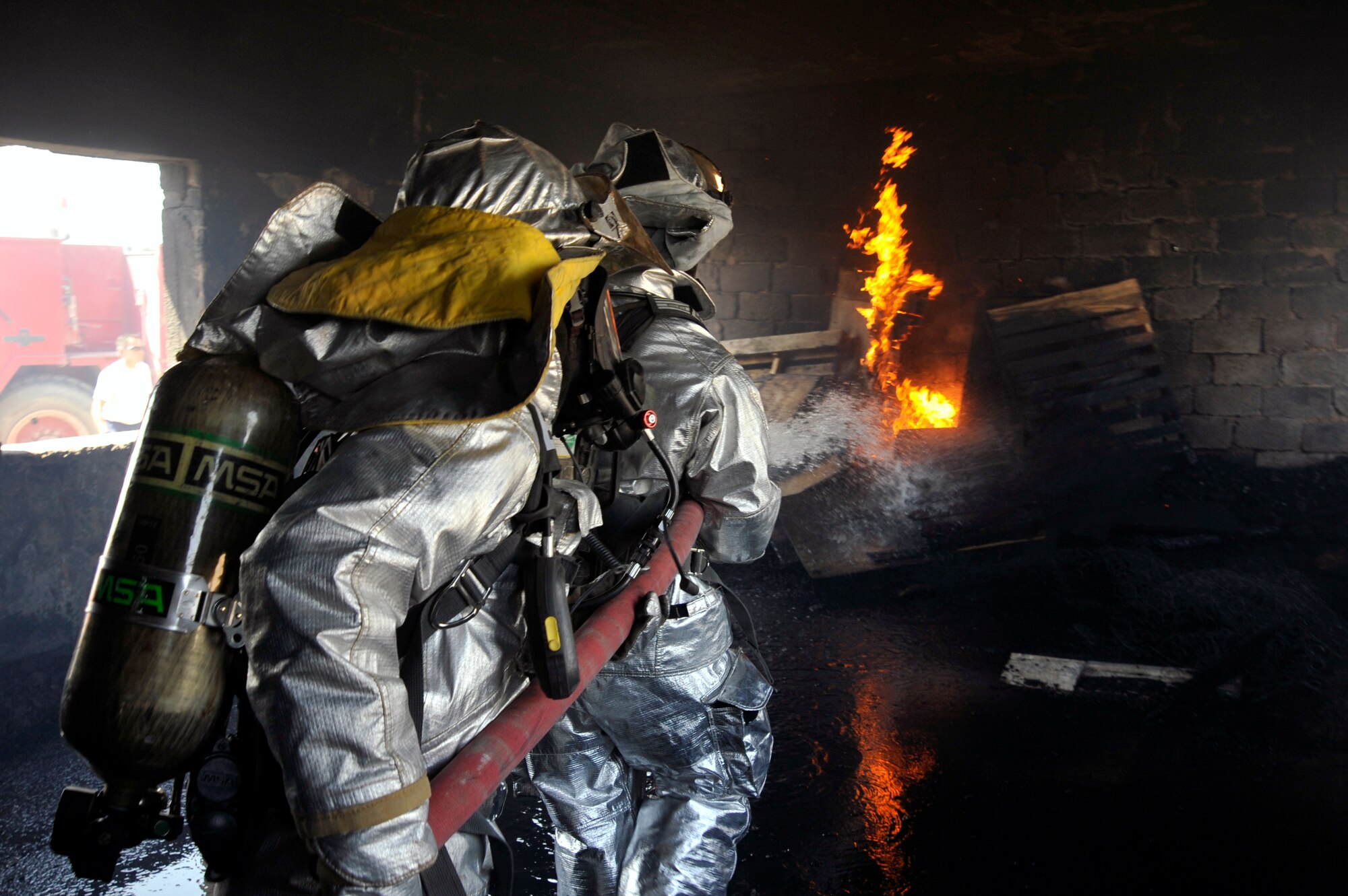 447th Expeditionary Civil Engineer Squadron firefighters extinguish a fire in a training room during live burn training, Aug. 9, 2010, at Baghdad International Airport, Iraq. Firefighters from the 447th ECES, BIAP and Iraqi air force, frequently train in structural firefighting, to improve their skills. ( U.S. Air Force photo by Senior Airman Perry Aston) (Released)