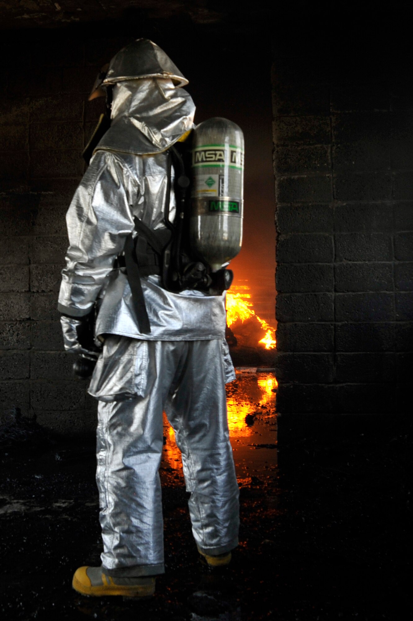 A 447th Expeditionary Civil Engineer Squadron firefighter waits for a fire to get bigger before attempting to extinguish it, during live burn training, Aug. 9, 2010, at Baghdad International Airport, Iraq. Firefighters from the 447th ECES, BIAP and Iraqi air force, frequently train in structural firefighting, to improve their skills. ( U.S. Air Force photo by Senior Airman Perry Aston) (Released)