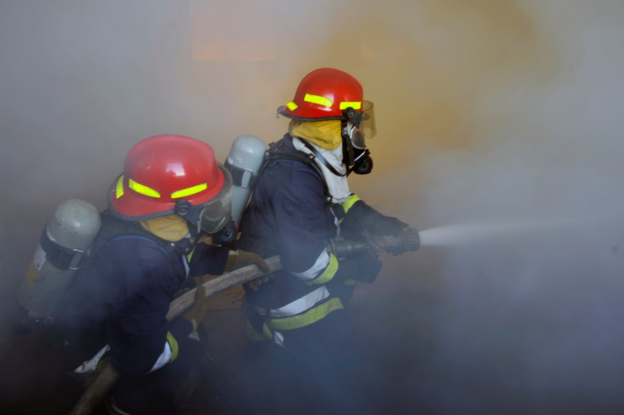 Iraqi air force firefighters extinguish a fire in a training room during live burn training, Aug. 9, 2010, at Baghdad International Airport, Iraq. Firefighters from the 447th ECES, BIAP and Iraqi air force, frequently train in structural firefighting, to improve their skills.( U.S. Air Force photo by Senior Airman Perry Aston) (Released)