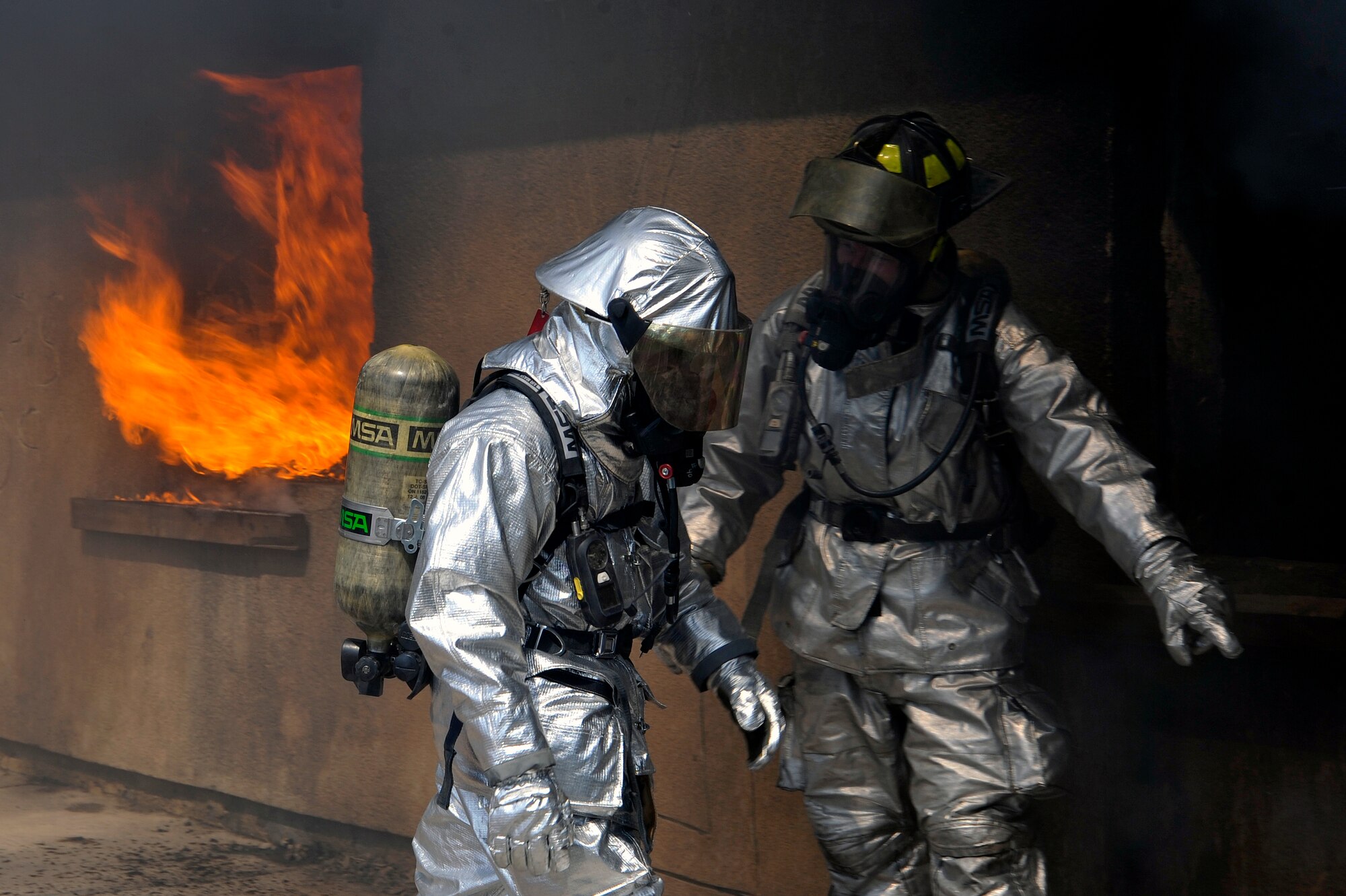 A 447th Expeditionary Civil Engineer Squadron and Baghdad International Airport firefighters prepare to enter a building during live burn training, Aug. 9, 2010, at BIAP, Iraq. Firefighters from the 447th ECES, BIAP and Iraqi air force, frequently train in structural firefighting, to improve their skills. ( U.S. Air Force photo by Senior Airman Perry Aston) (Released)