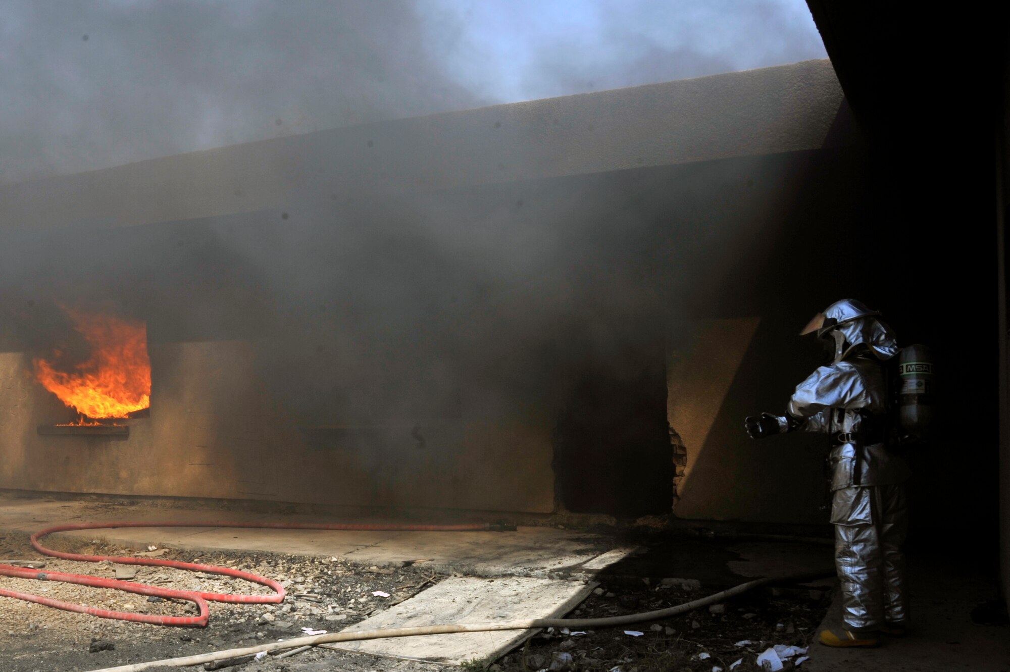 A 447th Expeditionary Civil Engineer Squadron firefighter waits for the rest of his crew during live burn training, Aug. 9, 2010, at Baghdad International Airport, Iraq. Firefighters from the 447th ECES, BIAP and Iraqi air force, frequently train in structural firefighting, to improve their skills. ( U.S. Air Force photo by Senior Airman Perry Aston) (Released)