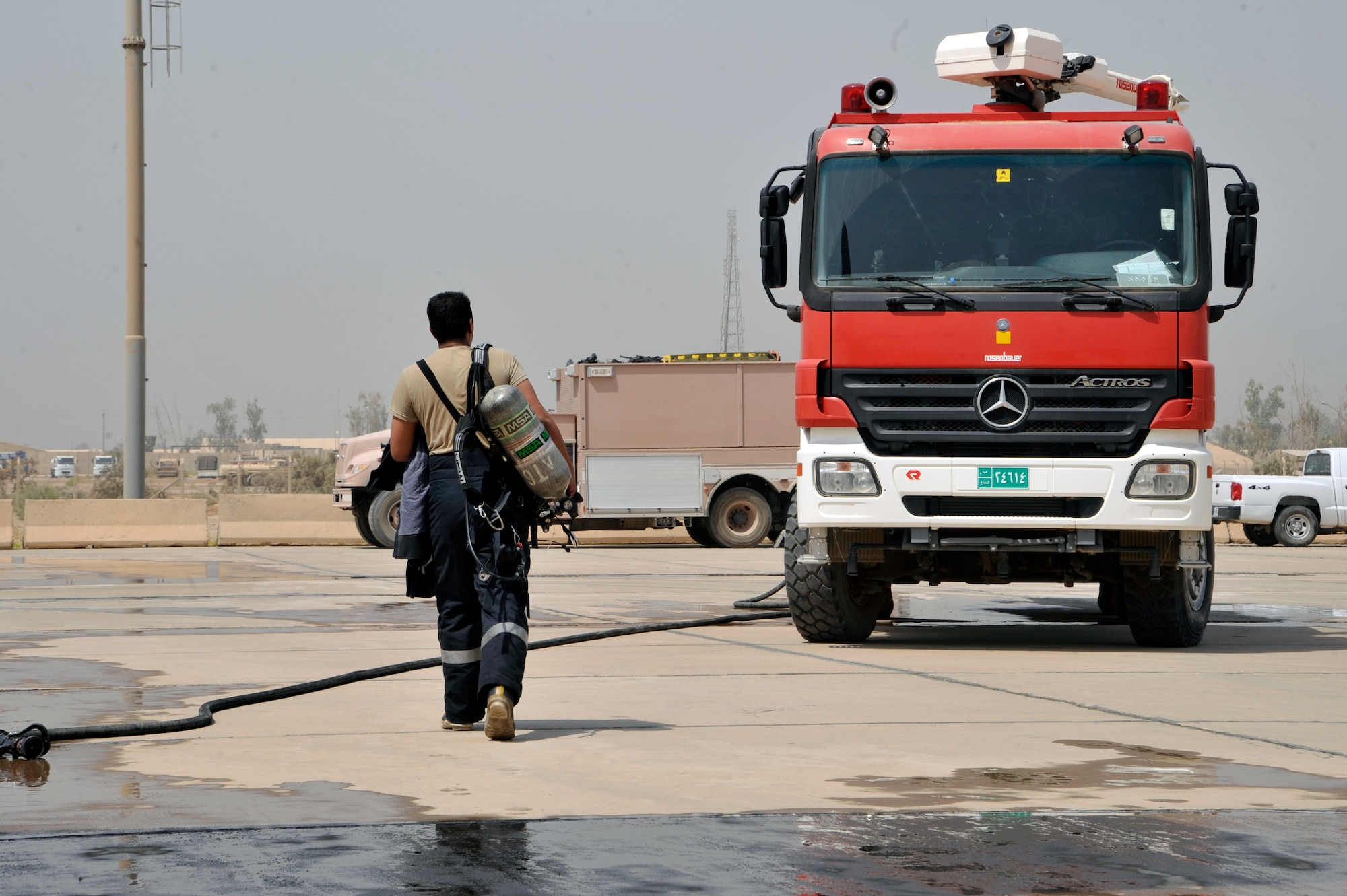 An Iraqi air force firefighter walks back to his aircraft crash truck after training during a simulated aircraft fire Aug. 5, 2010, at Al Muthana Air Base, Iraq. The firefighters demonstrated to Iraq training and advisory leaders, and Iraqi air force leadership, their ability to protect Iraqi air force assets and save lives. ( U.S. Air Force photo by Senior Airman Perry Aston) (Released)