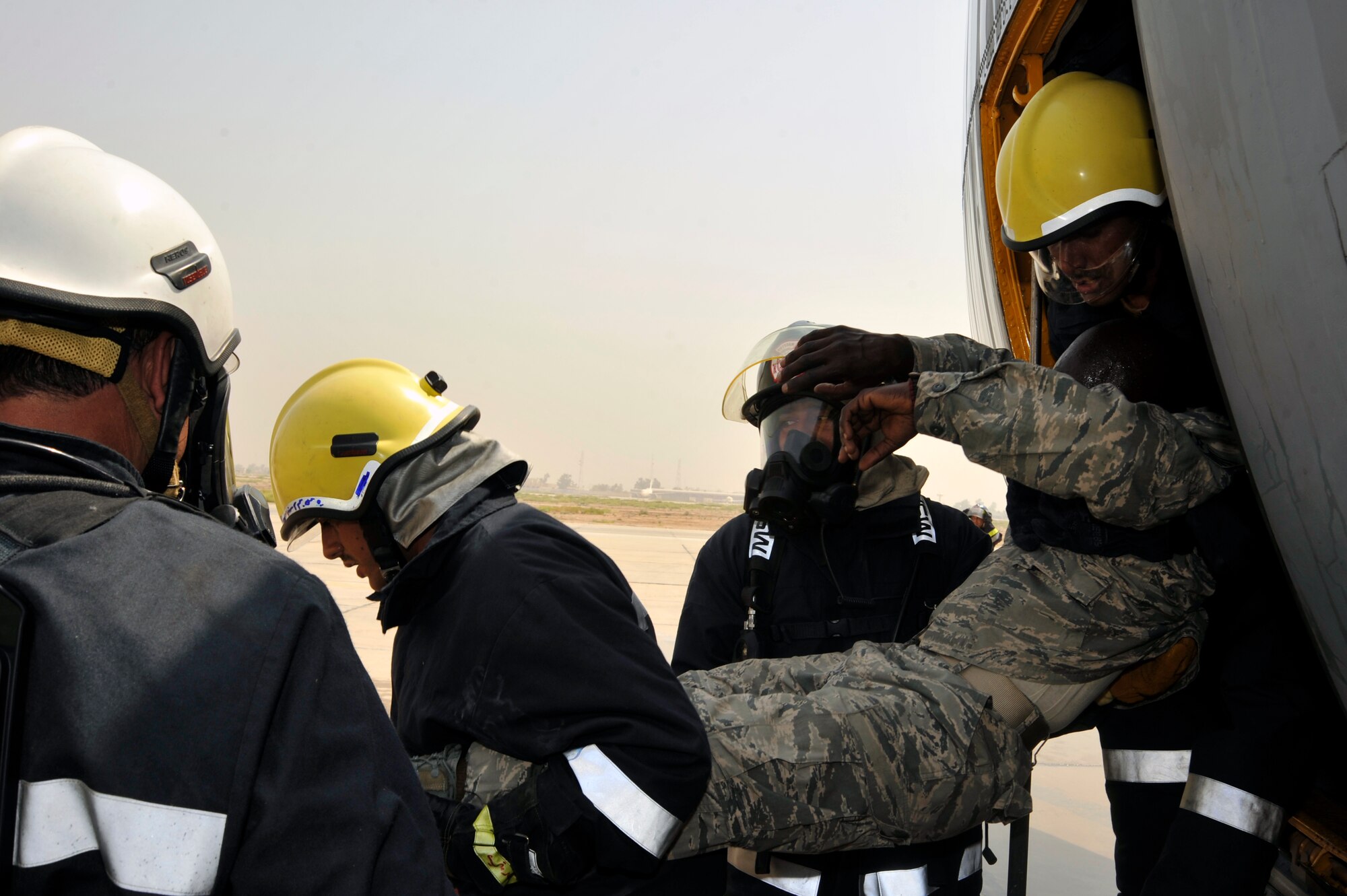 Iraqi air force firefighters extricate a victim from an Iraqi air force C-130 during a simulated aircraft fire Aug. 5, 2010 at New Al Muthana Air Base, Iraq. The firefighters demonstrated to Iraq training and advisory leaders, and Iraqi air force leadership, their ability to protect Iraqi air force assets and save lives. ( U.S. Air Force photo by Senior Airman Perry Aston) (Released)