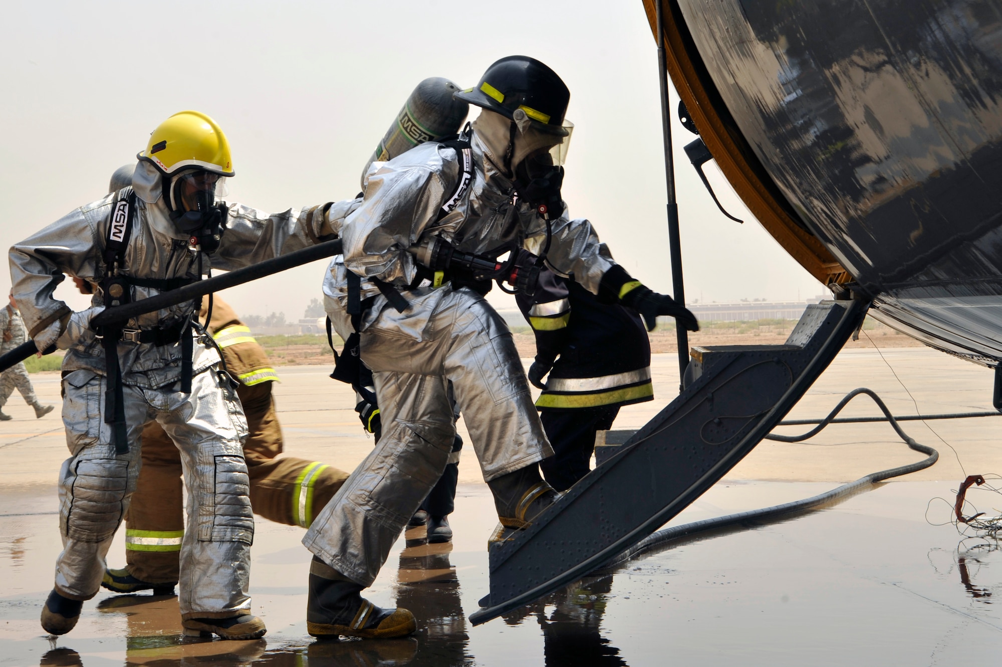 Iraqi air force firefighters enter an Iraqi air force C-130 during a simulated aircraft fire Aug. 5, 2010 at New Al Muthana Air Base, Iraq. The firefighters are being trained by 447th Expeditionary Civil Engineer Squadron firefighters in aircraft rescue and firefighting, and structural firefighting. ( U.S. Air Force photo by Senior Airman Perry Aston) (Released)