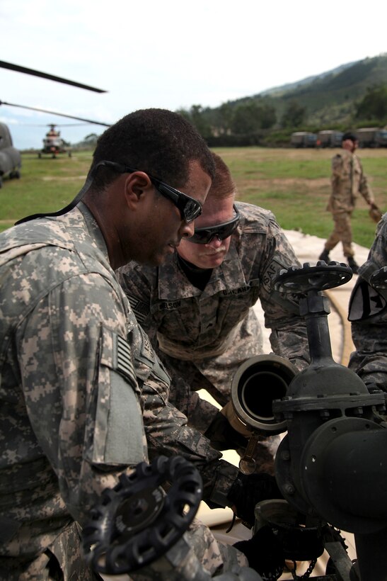 U.S. Army Sgt. Miguel Lugo, left, works with Sgt. Joseph Nelson to connect hoses to a fuel pump which is part of a forward area refueling point in Rubicon, Pakistan, Aug. 10, 2010. Lugo and Nelson are assigned to the 3rd Infantry Division's Company E, 2nd Battalion, 3rd Combat Aviation Brigade.