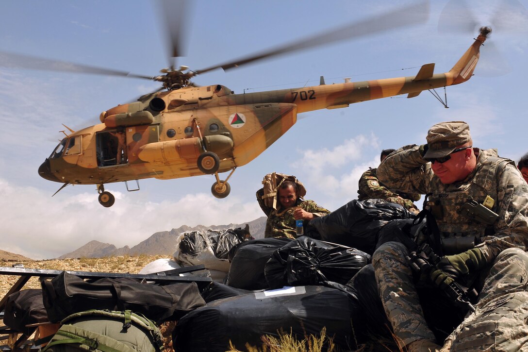 U.S. Air Force Tech Sgt. Jason Marsh braces himself against the wind and dirt from the liftoff of an Mi-17v5 transport helicopter on the Chinari village on the outskirts of Kabul, Afghanistan, Aug. 9, 2010. Airmen assigned to the Afghan Air Force 201st Corps, the U.S. Air Force 438th Air Expeditionary Wing and the 438th Air Expeditionary Advisory Wing prepared and delivered humanitarian aid consisting of school supplies for 600 students, sporting equipment, bedding, a large tent, and an all-weather Afghan flag.
