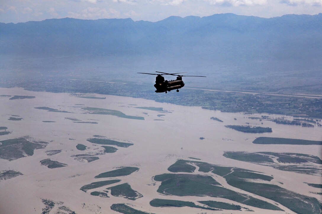 A U.S. Army CH-47 Chinook helicopter flies over the flood affected area in Pakistan on a return flight from delivering humanitarin assistance and evacuating personnel to the town of Khwazakhela, as part of the flood recovery effort in Khyber Pakhtunkhwa province, Pakistan, Aug 11, 2010.