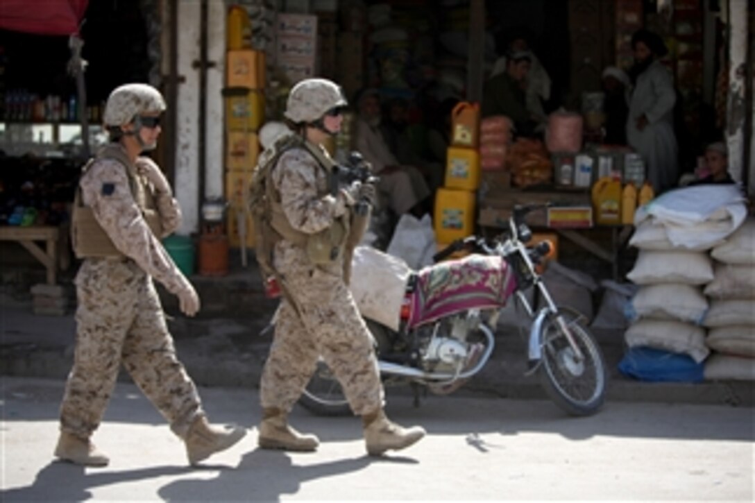U.S. Marine Cpl. Mary E. Walls (right), an ammunition technician, and linguist Sahar, both with a female engagement team, patrol with 1st Battalion, 2nd Marine Regiment in Musa Qa'leh, Afghanistan, on Aug. 6, 2010.  Walls and other female engagement team members patrolled local compounds around the district center to establish relationships with local people and talk with the women of the area in support of the International Security Assistance Force.  