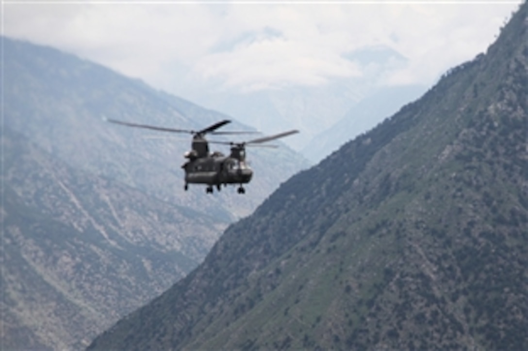 A U.S. Army CH-47 Chinook helicopter evacuates Pakistani civilians over a mountain pass in Pakistan, Aug. 5, 2010. Humanitarian relief and evacuation missions are being conducted as part of the disaster relief efforts to assist Pakistanis in flood-stricken regions of the nation.