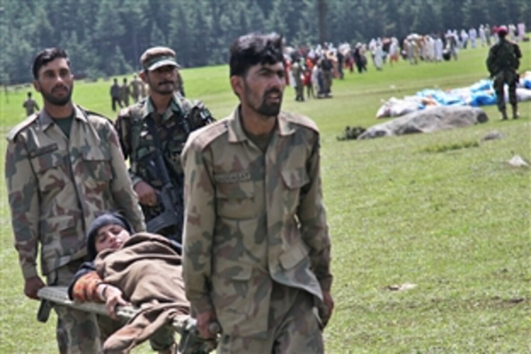 Pakistani servicemembers carry a civilian on a stretcher to a U.S. Army CH-47 Chinook helicopter during an evacuation mission in Khyber Pakhtunkhwa, Pakistan, Aug. 5, 2010. Humanitarian relief and evacuation missions are being conducted as part of the disaster relief efforts to assist Pakistanis in flood-stricken regions of the nation.