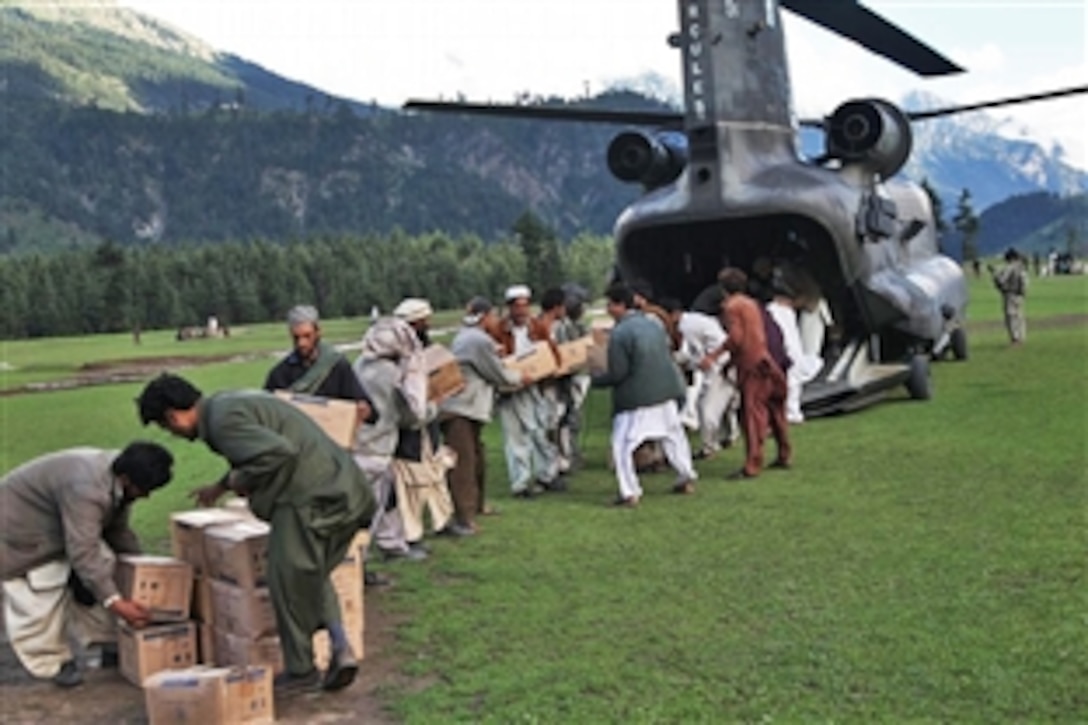 Men from the town of Kalam, Pakistan, form a chain to quickly unload a U.S. Army Chinook helicopter that is delivering humanitarian assistance and picking up victims of the flood in the Khyber Pakhtunkhwa province, Aug. 10, 2010.