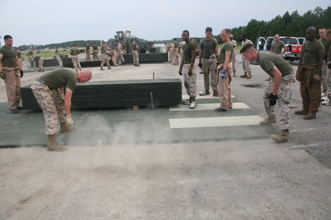 Marines with Marine Wing Support Squadron 271 lay matting on one of the taxiways aboard Marine Corps Auxiliary Landing Field Bogue Aug. 12. Matting is a nonslip surface used by the military for aircraft landing sites.