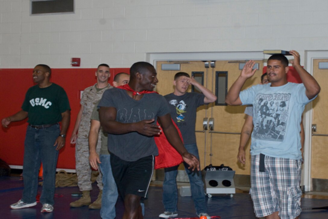 Sgt. Tavaris Douglas encourages fellow Marine, Sgt. Rene Valerio in the relay race during the Marine Corps Recruiting Command’s family day at Barber Physical Activity Center Aug. 12.