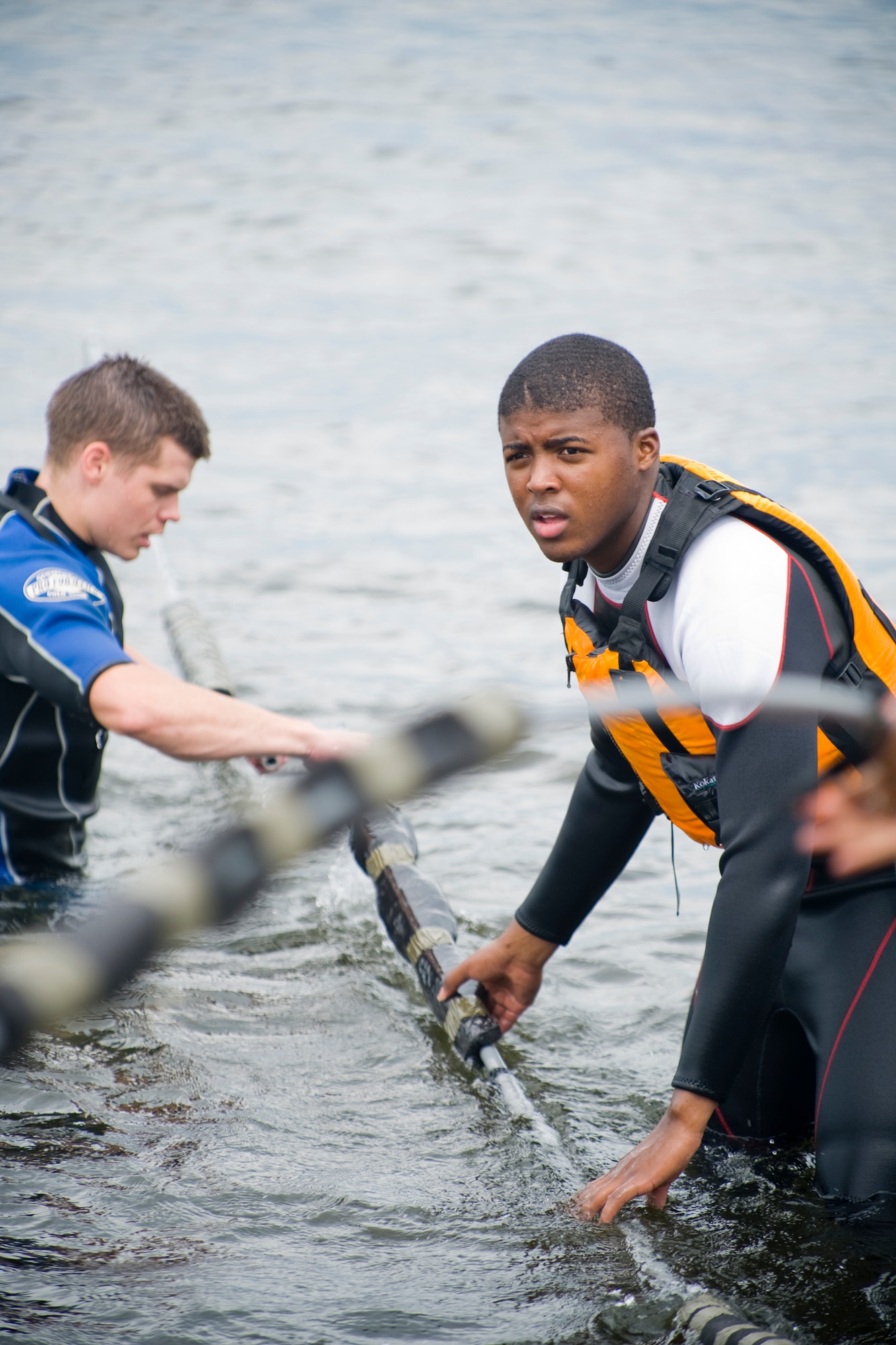 MISAWA AIR BASE, Japan -- Senior Airman Justin Poe (left), 35th Logistics Readiness Squadron unit fitness performance monitor, and Airman Joshua Hoskins (right), 35th Operations Support Squadron air crew flight equipment apprentice, prepare equipment before water survival training Aug. 12 at Lake Ogawara. Airmen Hoskins and Poe volunteered as augmentees to assist with the training. (U.S. Air Force photo/Senior Airman Jamal D. Sutter)