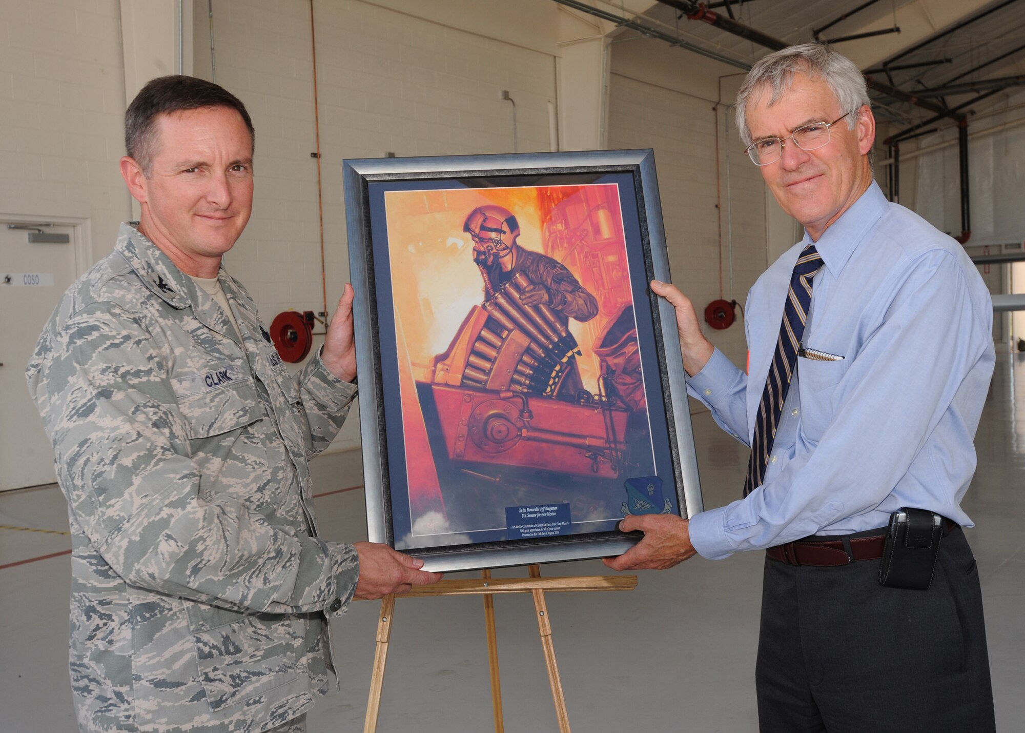 CANNON AIR FORCE BASE, N.M. - Col. Stephen Clark, 27th Special Operations Wing commander presents New Mexico Senator Jeff Bingaman with a framed photo August 11. The photo represents all of the air commandos of Cannon Air Force Base. (U.S. Air Force photo by Airman 1st Class Maynelinne De La Cruz)