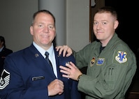 Tech. Sgt. Shawn Compton, 558th Flying Training Squadron instructor, pins wings onto Master Sgt. Steve Metcalf, remotely piloted aircraft sensor operator, during a graduation ceremony Aug. 12 at Randolph Air Force Base, Texas. Although graduates during the past year received diplomas, Sergeant Metcalf was the first graduating sensor operator to receive the new wings. A total of 35 airmen graduated and received wings at the ceremony. (U.S. Air Force photo/David Terry) 