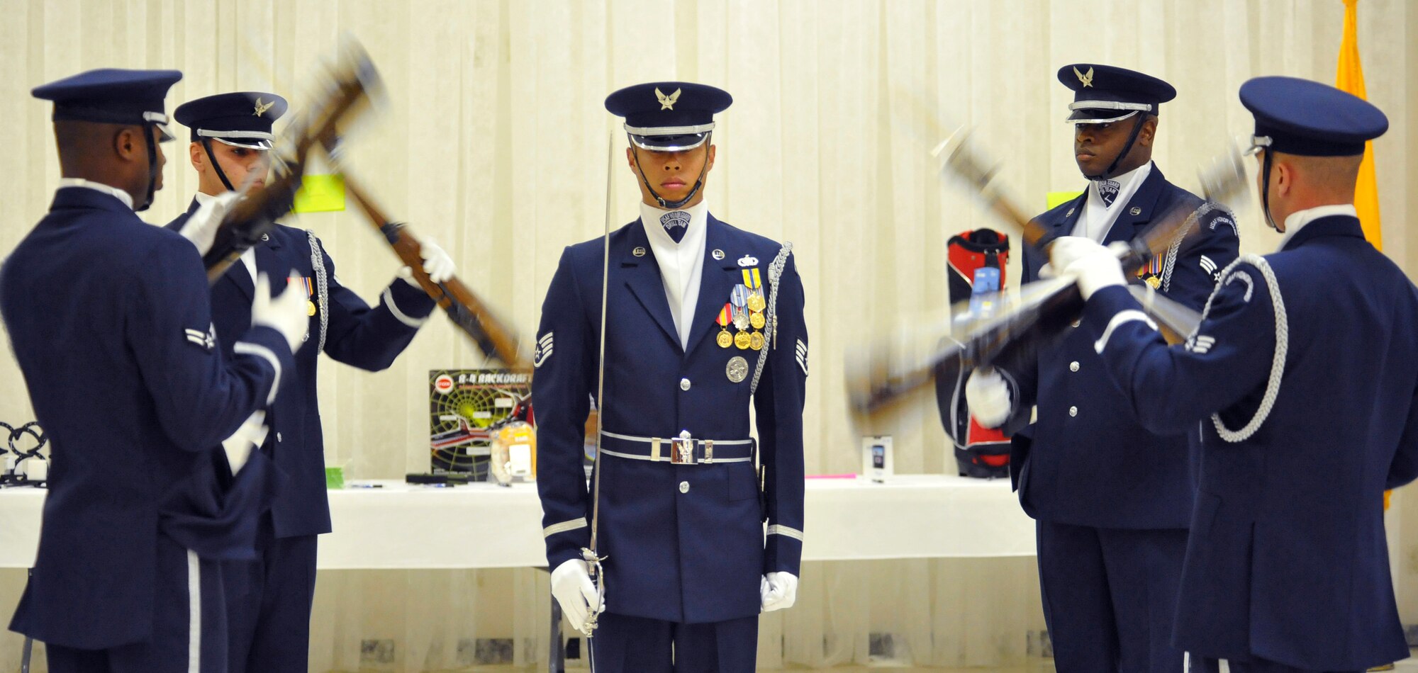 ALAMOGORDO, N.M. -- Staff Sgt. Jonathan Tomita, a member of the U.S. Air Force Honor Guard Drill Team, stands in the middle of a four-man team demonstration for the Operation Wounded Warrior Dine and Dance held at the Elks Lodge Aug. 7, 2010. Sixteen members from the AF Honor Guard also performed for the base populous at Holloman Air Force Base a day earlier. The AF Honor Guard Drill Team is the traveling component of the USAF Honor Guard and inspires Air Force awareness among military and civilian audiences through its complex drill routine. (U.S. Air Force photo by Senior Airman Veronica Stamps / Released)
