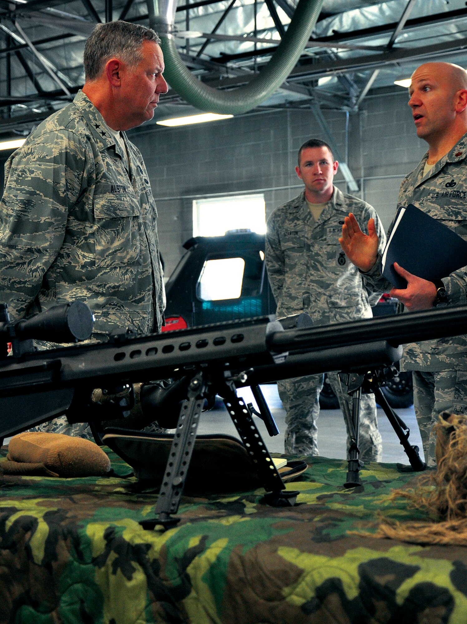Maj. Gen. C. Donald Alston, 20th Air Force commander, discusses the weapons used on the firing range with Maj. Jeffrey Rowsey, 90th Ground Combat Training Squadron commander, and 1st Lt. Alexander Stanton, 90th GCTS operations officer during his visit to Camp Guernsey on Aug. 5. (U.S. Air Force photo by Airman 1st Class Daniel Gage)