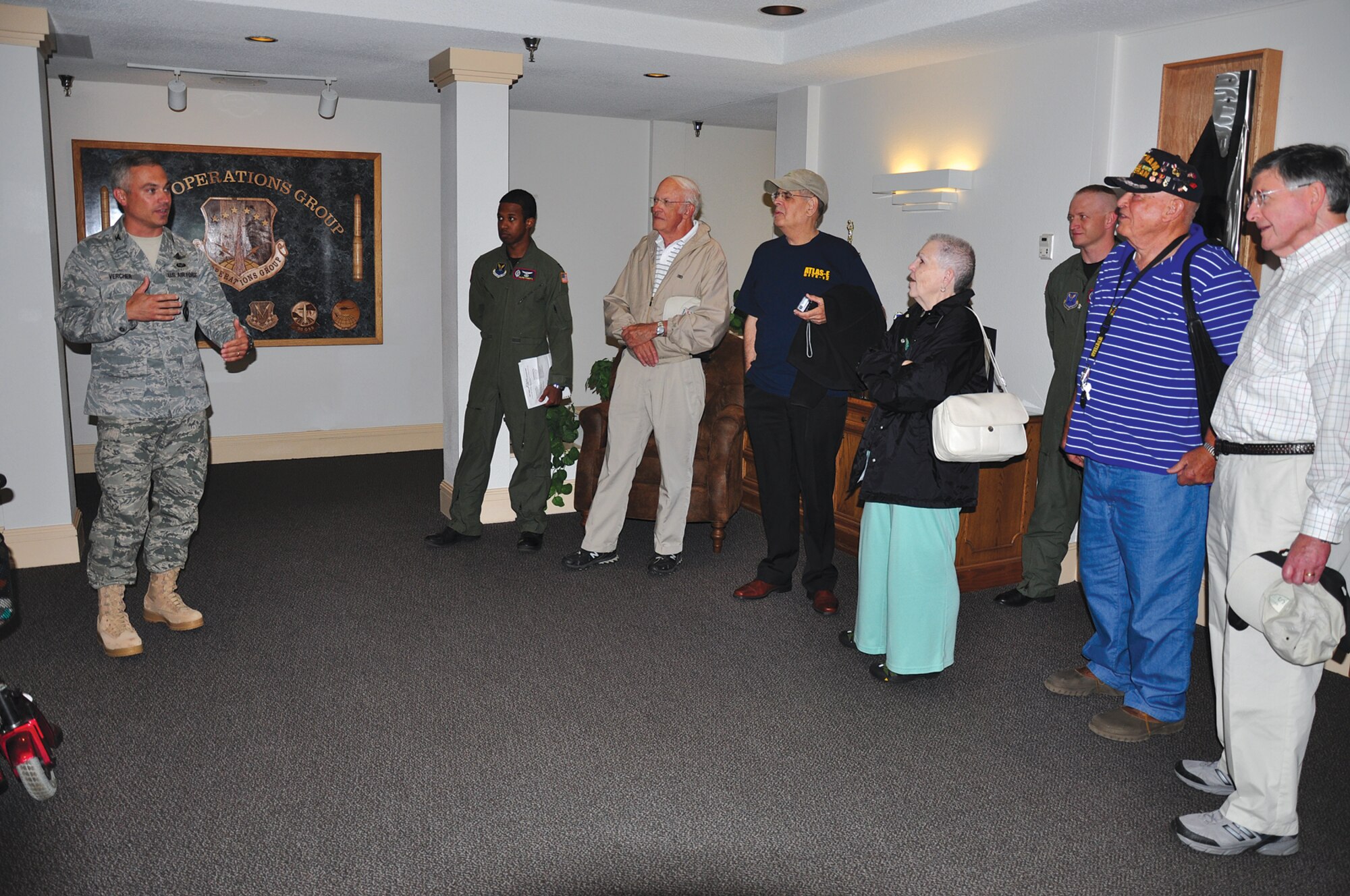 Col. Robert Vercher, 90th Operations Group commander, briefs a group of former Atlas-E crew members who were once stationed here in the operations group building Aug. 3. The 10-person group asked questions about crew teams, food on the sites, training, etc.  “It was such a privilege to host these individuals,” said Colonel Vercher. “They laid an important foundation to the mission of deterrence we still proudly execute today.” (U.S. Air Force photo by 1st Lt. Brooke Brzozowkse)