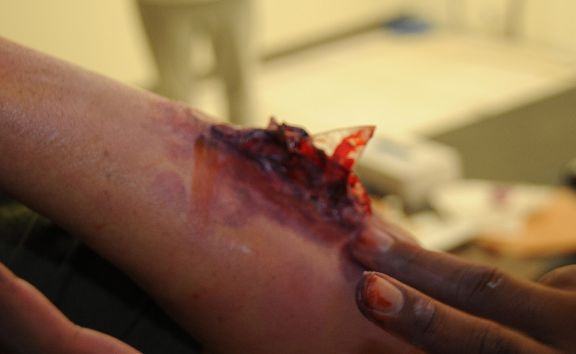 Medics from the 421st Combat Training Squadron applied makeup to a civilian role player to simulate a shrapnel  arm wound before the start of a scenario for Eagle Flag Aug. 5 at Joint Base McGuire-Dix-Lakehurst. The exercise tested emergency officials’ ability to respond to a hurricane in New Jersey. (U.S. Air Force photo/Airman 1st Class Bryan Swink)