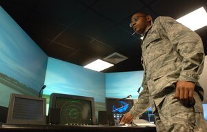 LANGLEY AIR FORCE BASE, Va. -- Airman 1st Class Aaric Ballard, 1st Operations Support Squadron air traffic controller, issues instructions to simulated aircraft using the air traffic control tower simulator Aug. 11. Trainees use real equipment as they work though a variety of scenarios, using video simulations of airfield and airspace operations, designed to mimic actual tower operations in a safe training environment. (U.S. Air Force photo/Airman 1st Class Jason J. Brown)