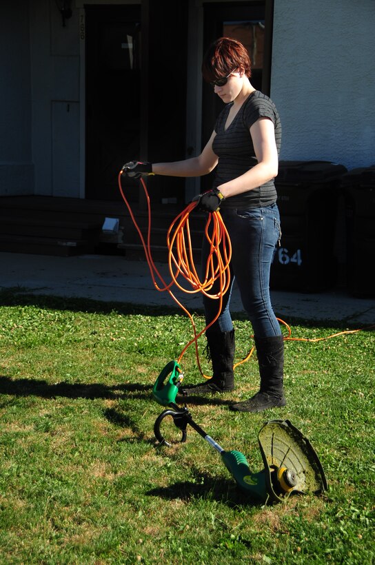 ELLSWORTH AIR FORCE BASE, S.D. -- Airman 1st Class Megan Dix, Air Force Financial Services Center travel technician, wraps up a cord to an electric weed-eater, Aug. 12.  Always keep all supplies and equipment together to ensure nothing gets lost or misplaced. (U.S Air Force photo/Airman 1st Class Anthony Sanchelli)

