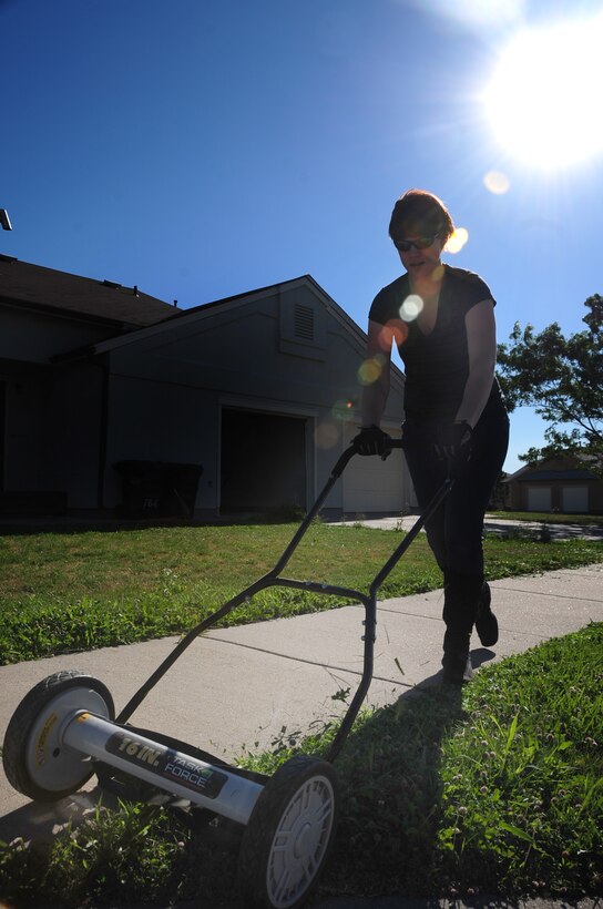 ELLSWORTH AIR FORCE BASE, S.D. -- Airman 1st Class Megan Dix, Air Force Financial Services Center travel technician, cuts the grass using a manual push mower, Aug. 12.  Keeping the blades on the lawn mower sharp allows the machine to work at its top performance. (U.S Air Force photo/Airman 1st Class Anthony Sanchelli)
