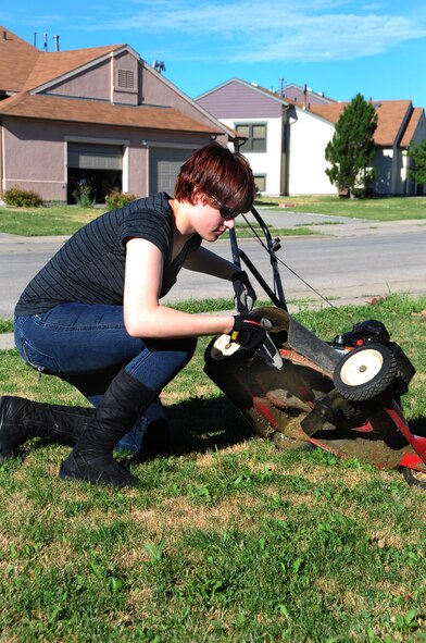 ELLSWORTH AIR FORCE BASE, S.D. -- Airman 1st Class Megan Dix, Air Force Financial Services Center travel technician, checks the underside of a lawn mower before cutting the grass, Aug. 12.  It’s important to check the gas, oil and the blades of the lawn mower before starting the engine. (U.S Air Force photo/Airman 1st Class Anthony Sanchelli)
