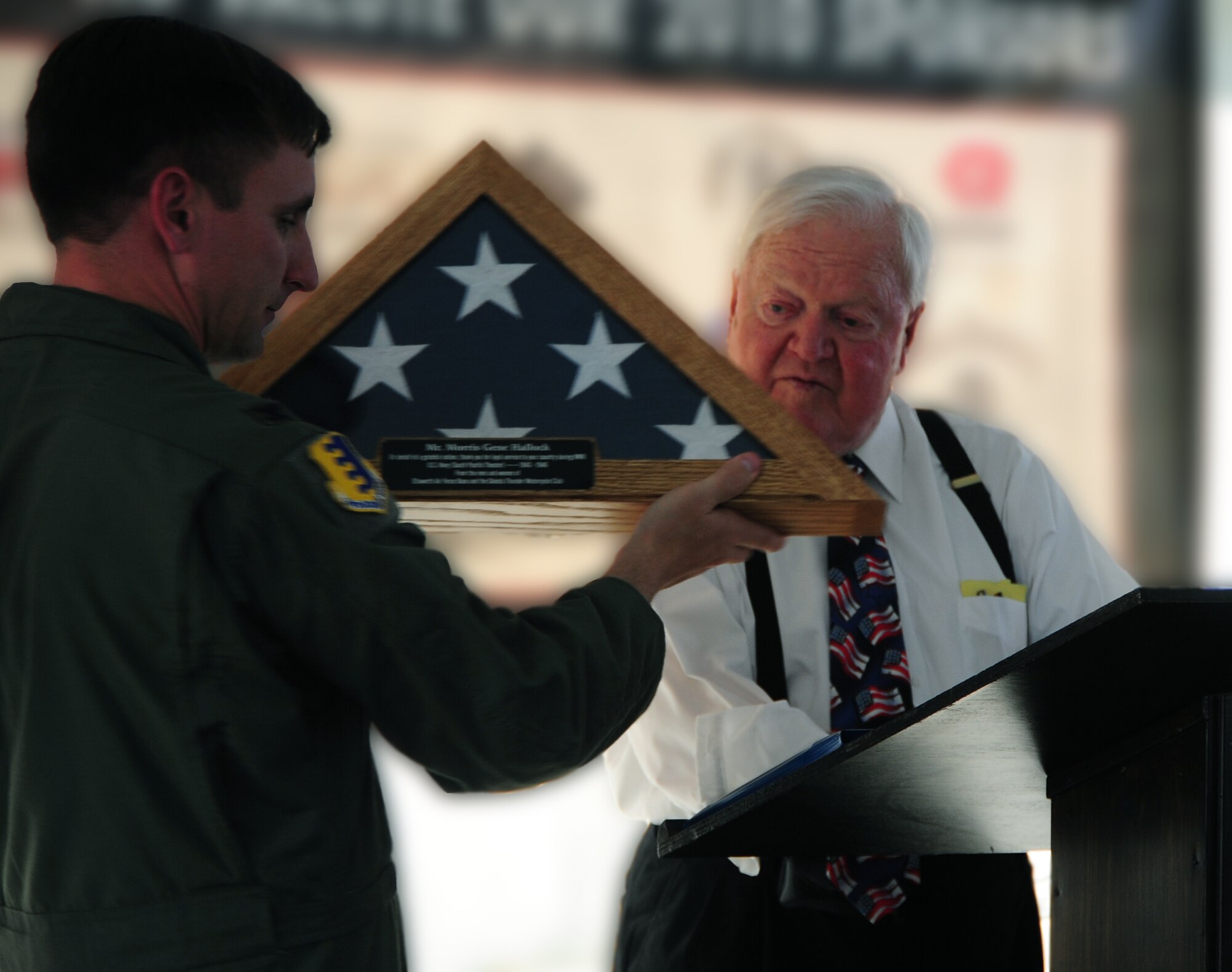ELLSWORTH AIR FORCE BASE, S.D. -- (Left to right) Col. Jeffery Taliaferro, 28th Bomb Wing commander, presents a flag, flown on a B-1B Lancer, to Morris Hallock, World War II veteran and resident of Sturgis, S.D., Aug 10. Morris Hallock was honored on Military Appreciation Day during the Sturgis Motorcycle Rally. (U.S. Air Force photo/Airman 1st Class Anthony Sanchelli)