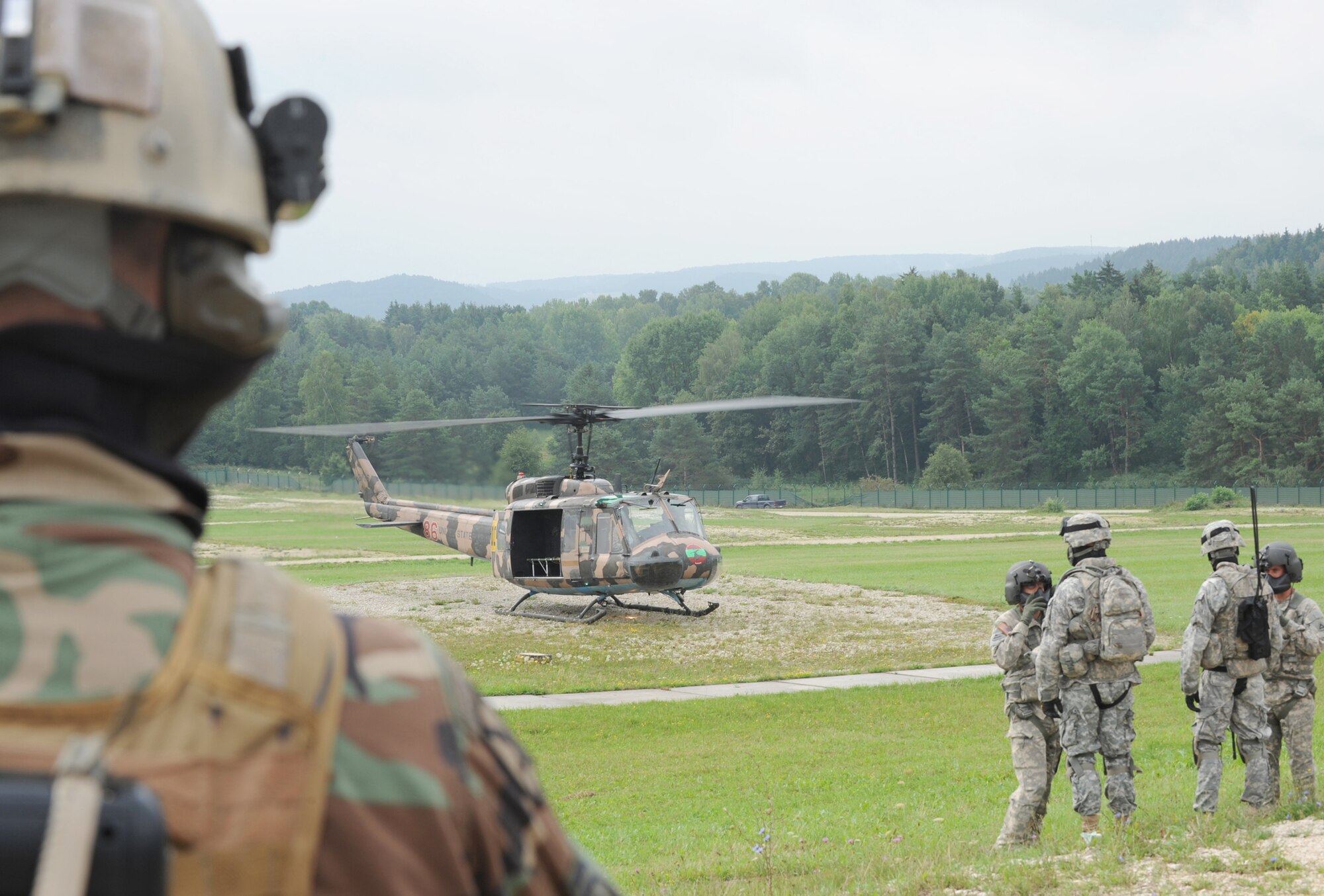 Air Force and Army members wait to load in a UH-1 Iroquois for an air assault mission scenario Aug. 3, 2010, during exercise Allied Strike 10 at Hohenfels, Germany. (U.S. Air Force photo/Senior Airman Caleb Pierce)