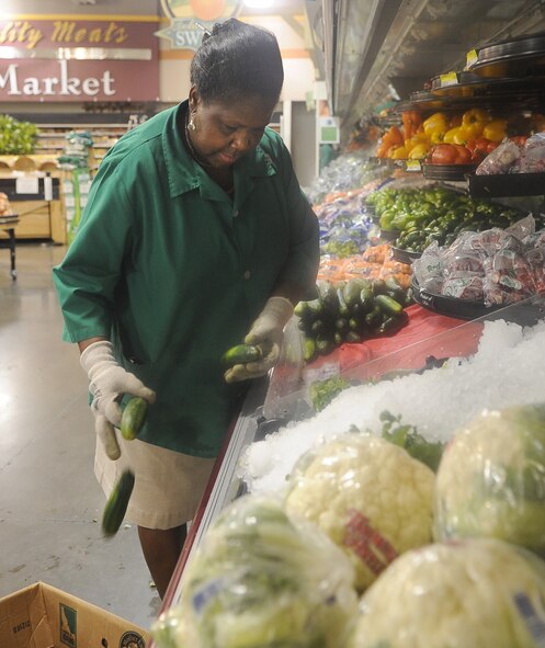 BARKSDALE AIR FORCE BASE, La. - Edith Banks, Commissary produce manager, helps cull cucumbers for placement of fresh ones Aug. 9 at the Barksdale Commissary. Trucks deliver fresh produce in the early morning Tuesday through Saturday every week and employees must receive and quality control all products. (U.S. Air Force photo/Senior Airman Amber Ashcraft) (RELEASED)